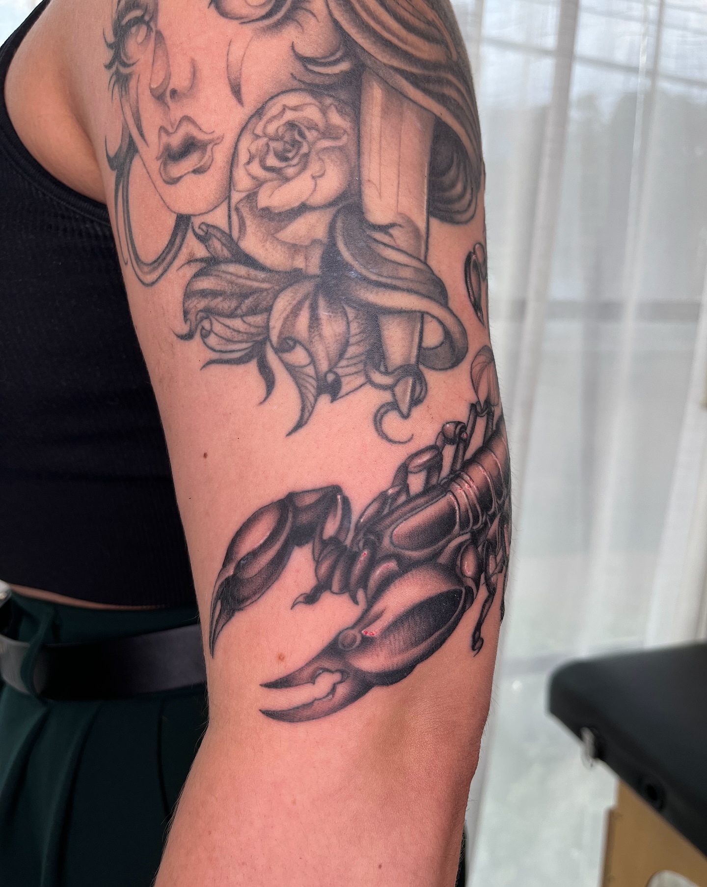 Woman with rose and scorpion American traditional tattoo on the forearm by Kyla Jae