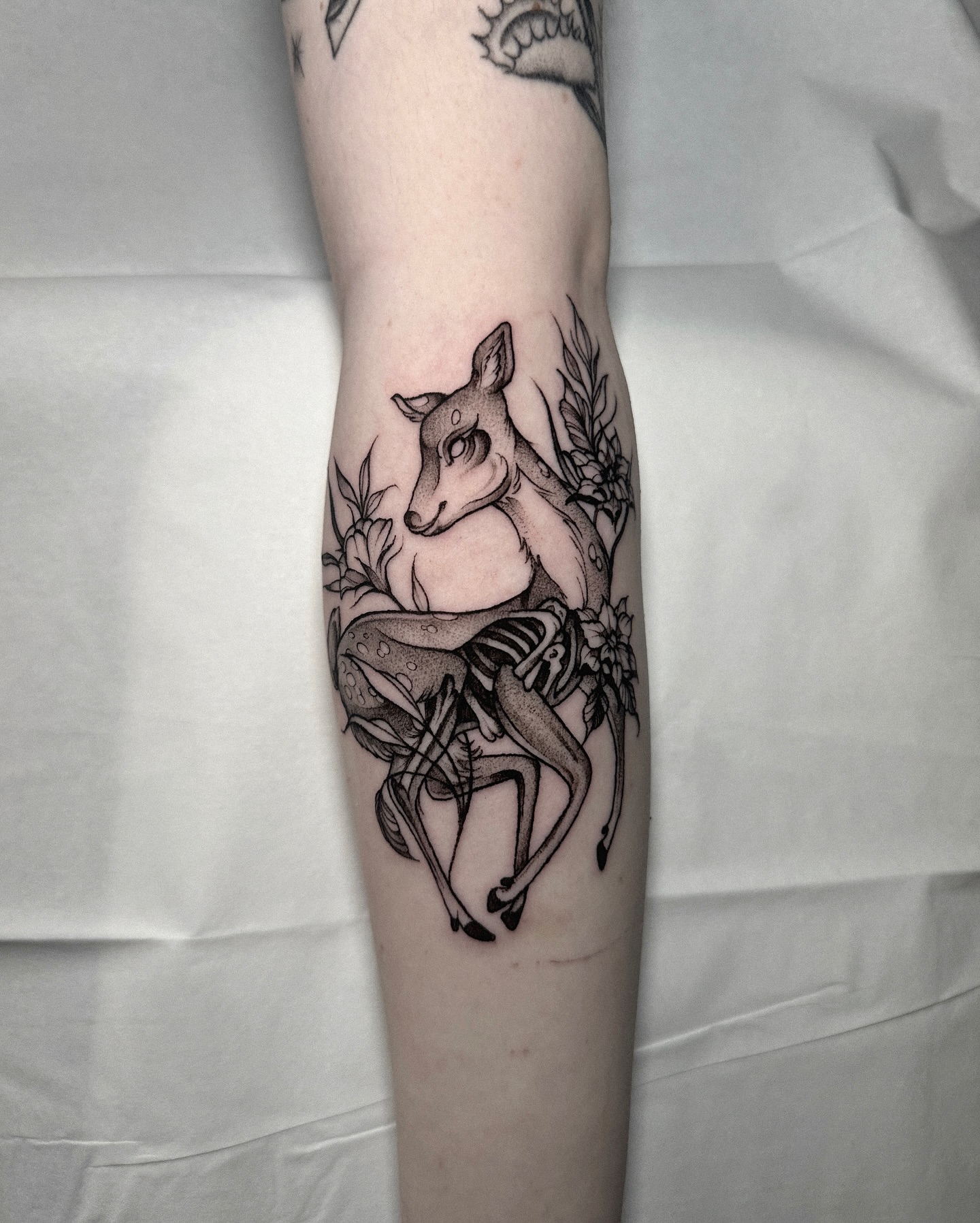 Deer and floral realism tattoo on the forearm by Macayla Myers