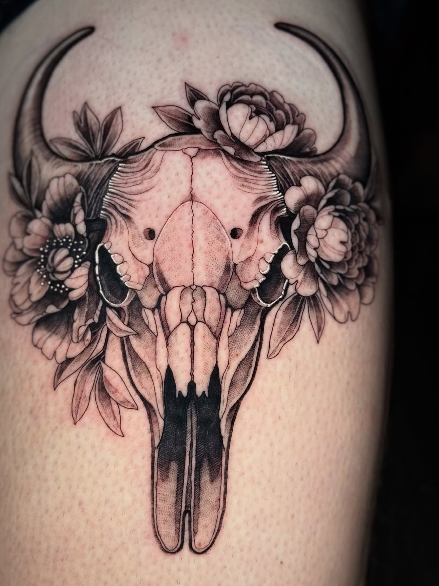 Bull skull with flowers black and grey tattoo on the thigh by Lydia Jude