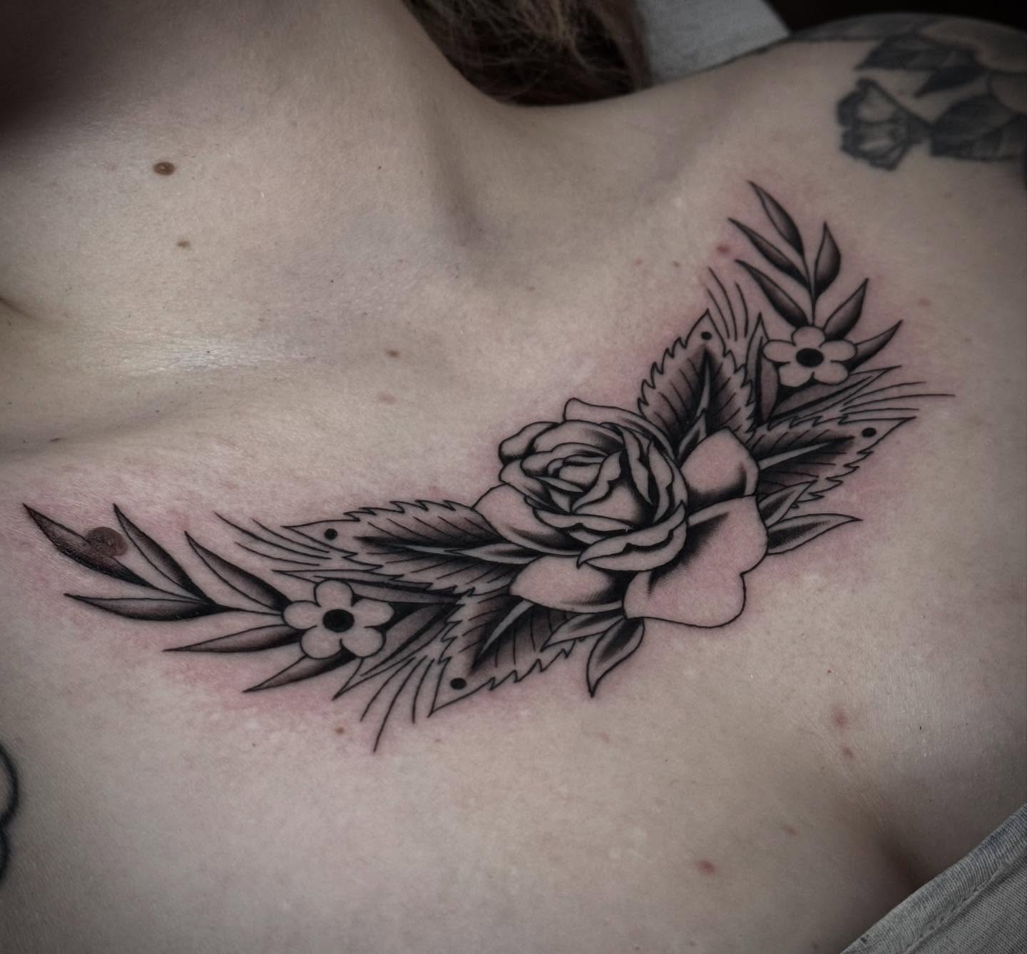 Floral arrangement black and grey tattoo on the chest by Ally noel