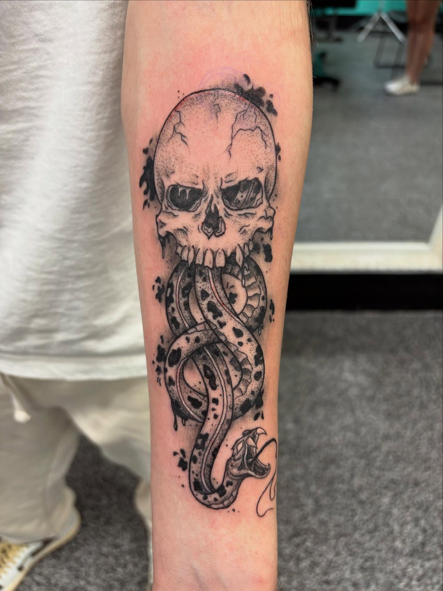 Skull and snake dotwork tattoo on the forearm by Jayda Shell
