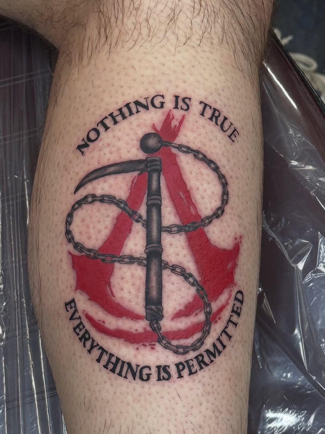 Assassin's Creed symbol with quote tattoo on the forearm by Christian Colón, Nashville, Tennessee