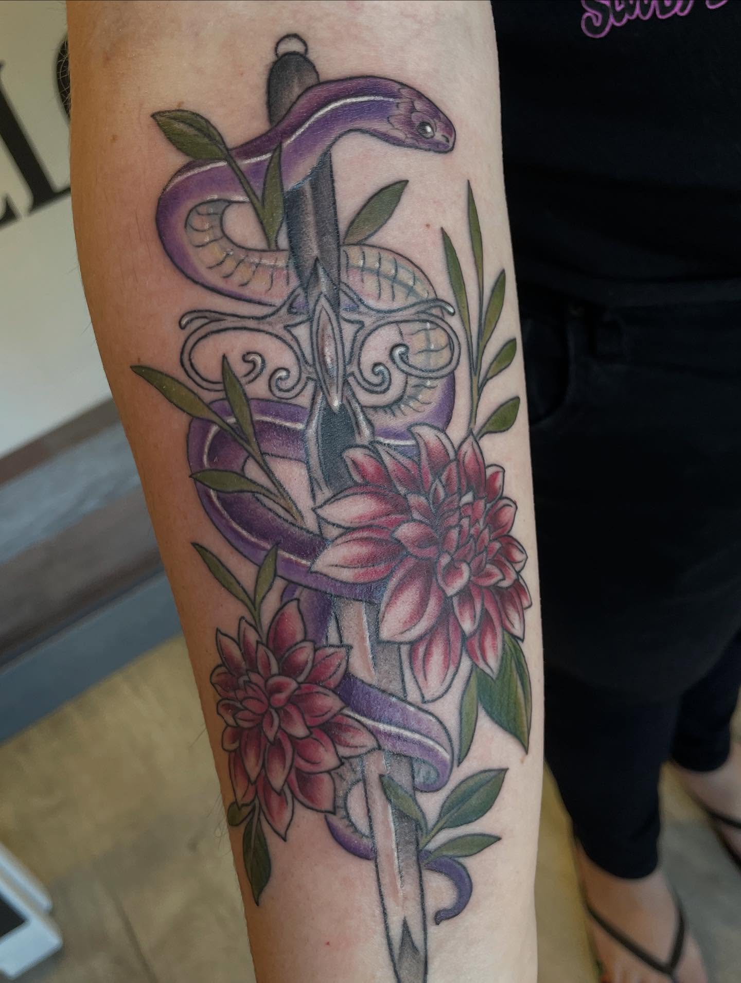 Snake and flowers new school tattoo on the forearm by Stevie Timmreck, Utica, Michigan
