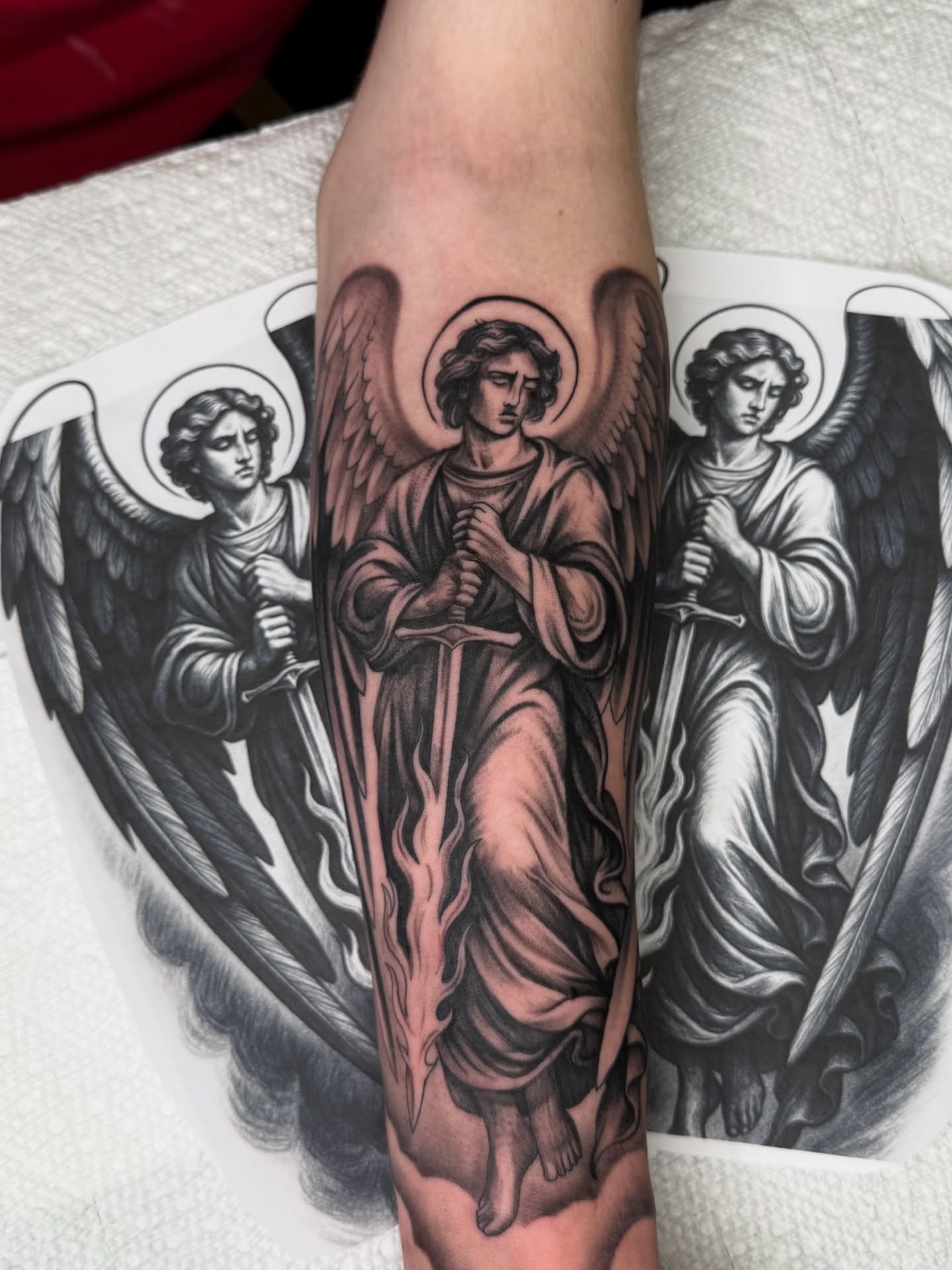 Angels black and grey tattoo on the forearm by Christian Hood