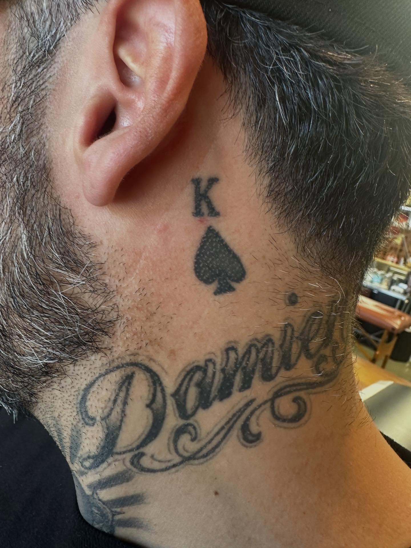 Spade and name black and grey tattoo on the neck by Dave G