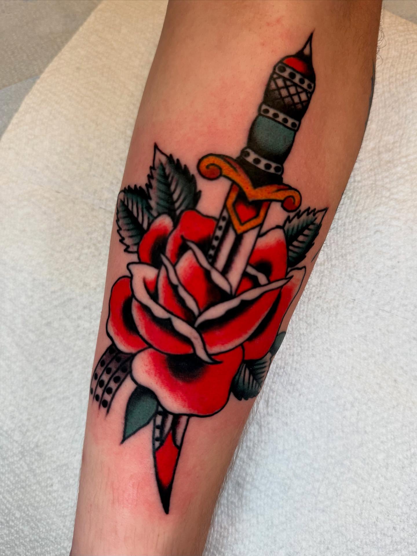 Rose and dagger American traditional tattoo on the forearm by Cody Petkus
