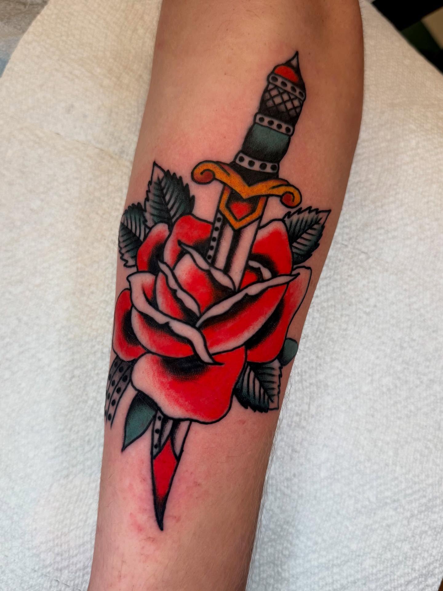 Sword through rose American traditional tattoo on the forearm by Cody Petkus