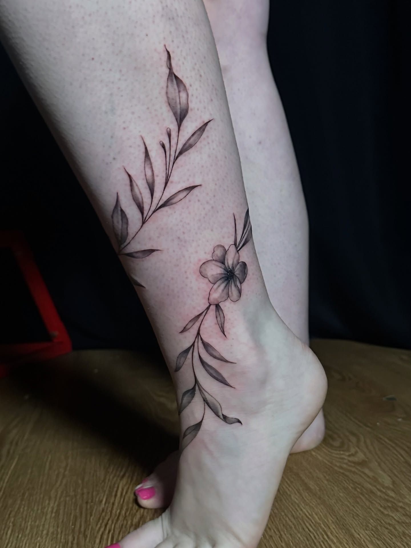 Flower and leaves black and grey tattoo on the foot by Tyler Reep