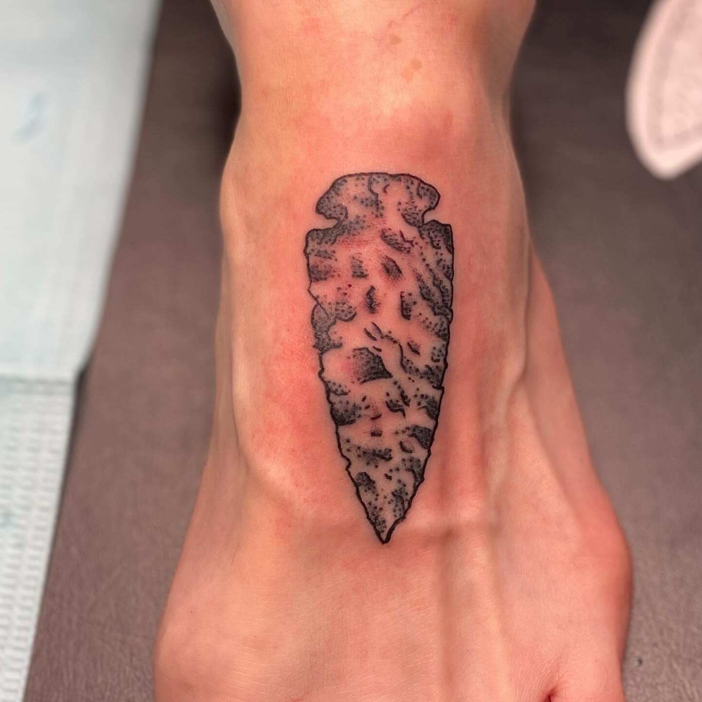 Arrowhead black and grey tattoo on the foot by Tommy O'Connell
