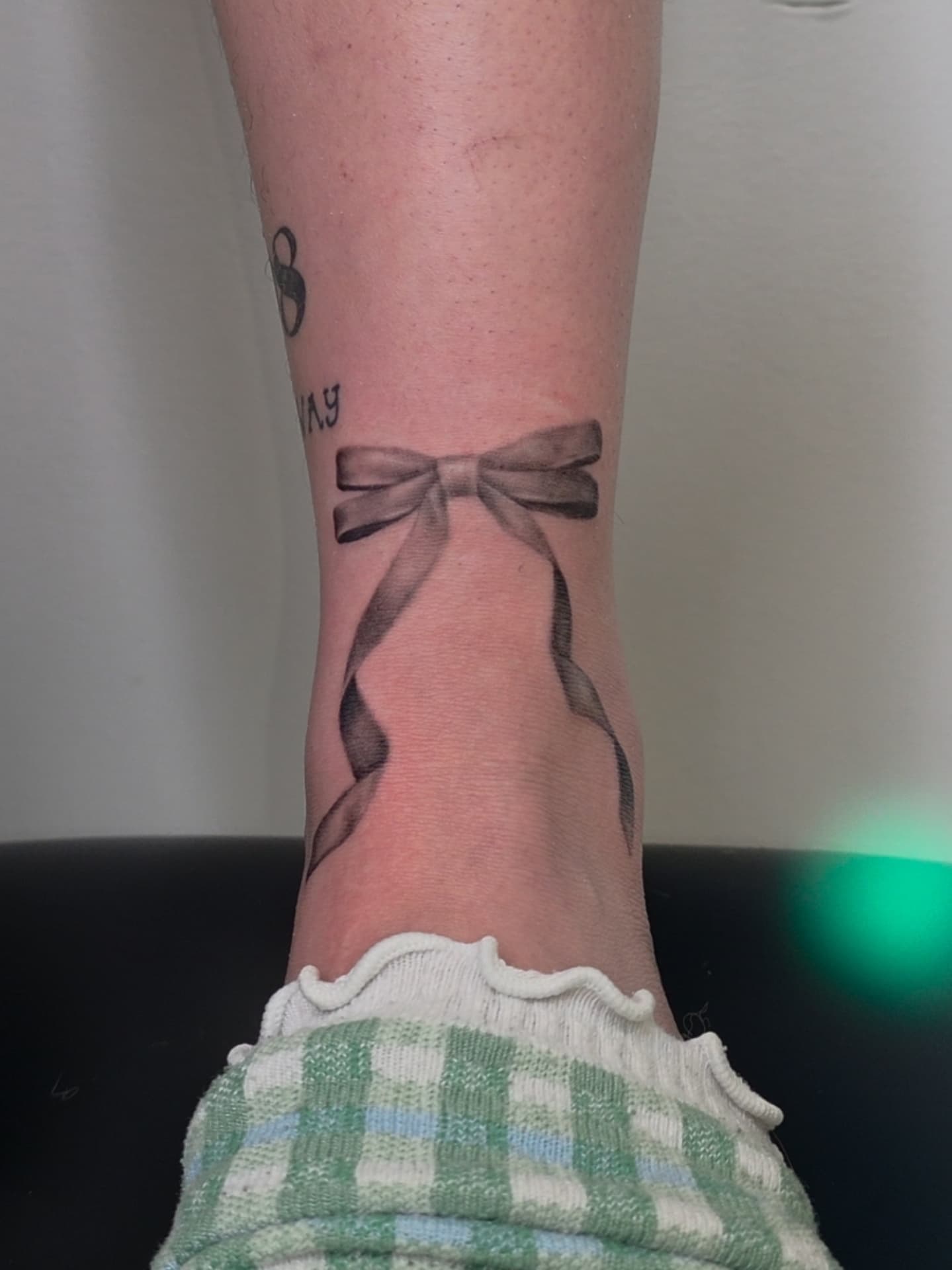 Bow black and grey tattoo on the calf by Ashley Johnson, Knoxville, Tennessee