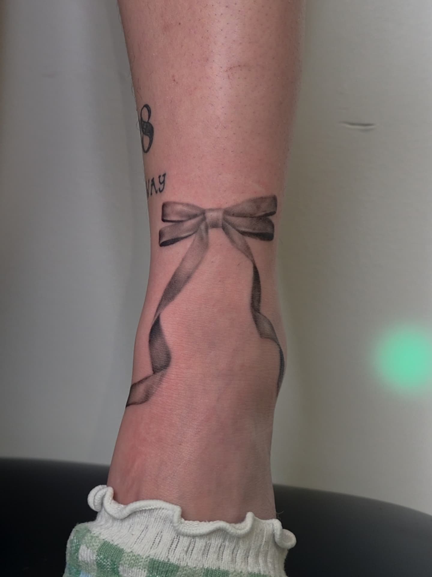 Bow black and grey tattoo on the foot by Ashley Johnson, Knoxville, Tennessee