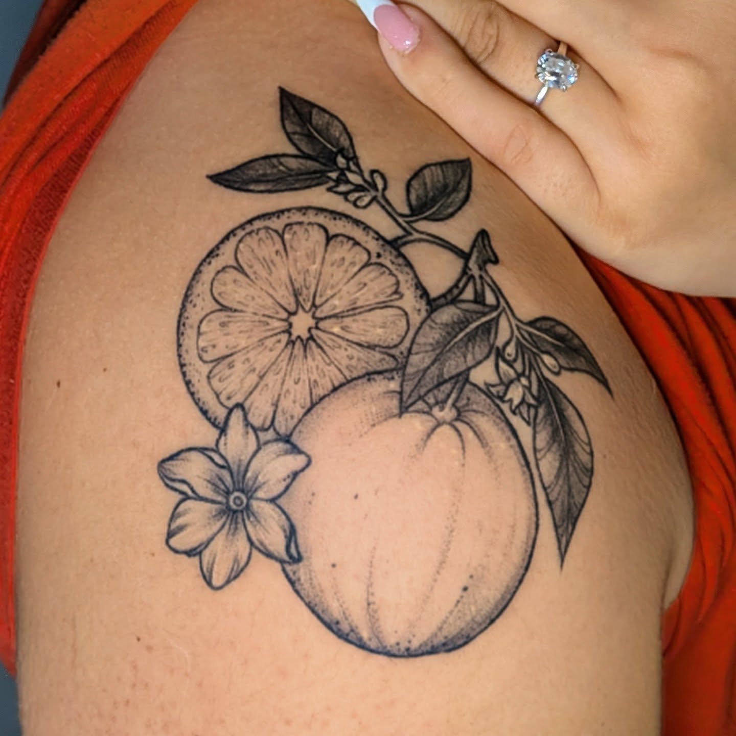 Orange and flower black and grey tattoo on the shoulder by Shannon