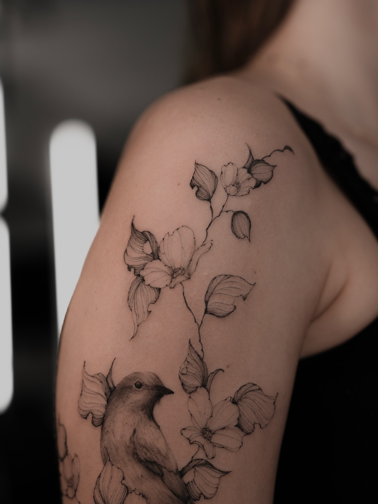 Bird and flowers black and grey tattoo on the shoulder by Marek