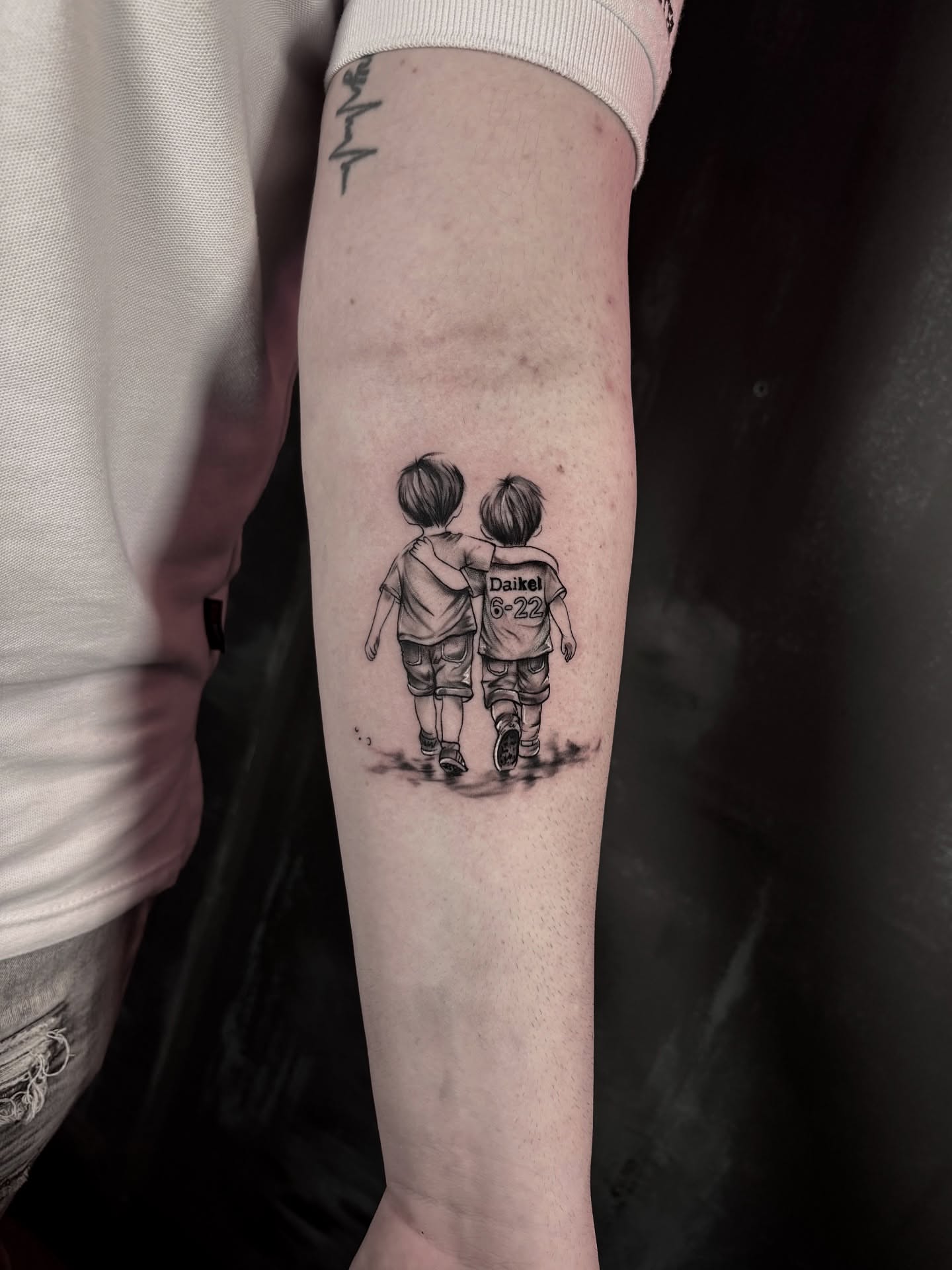Two children walking realism tattoo on the forearm by Keyla Valdes, Miami, Florida