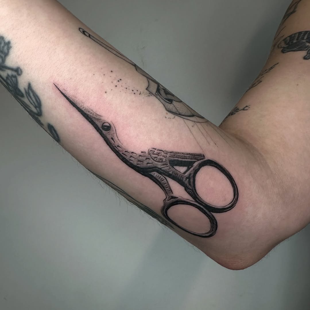 Ornate scissors minimalist tattoo on the forearm by reid - tattoo artist