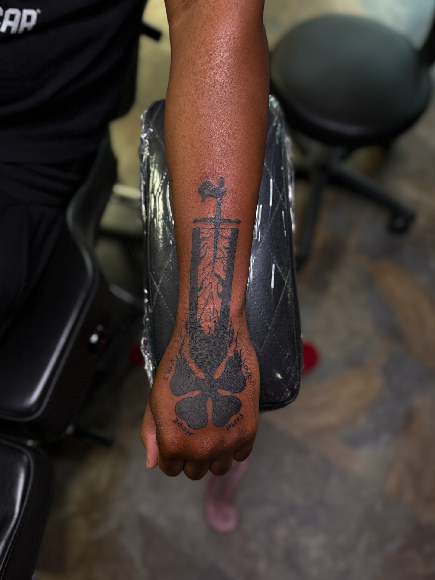 Sword and roots black and grey tattoo on the forearm by Yohana Vargas