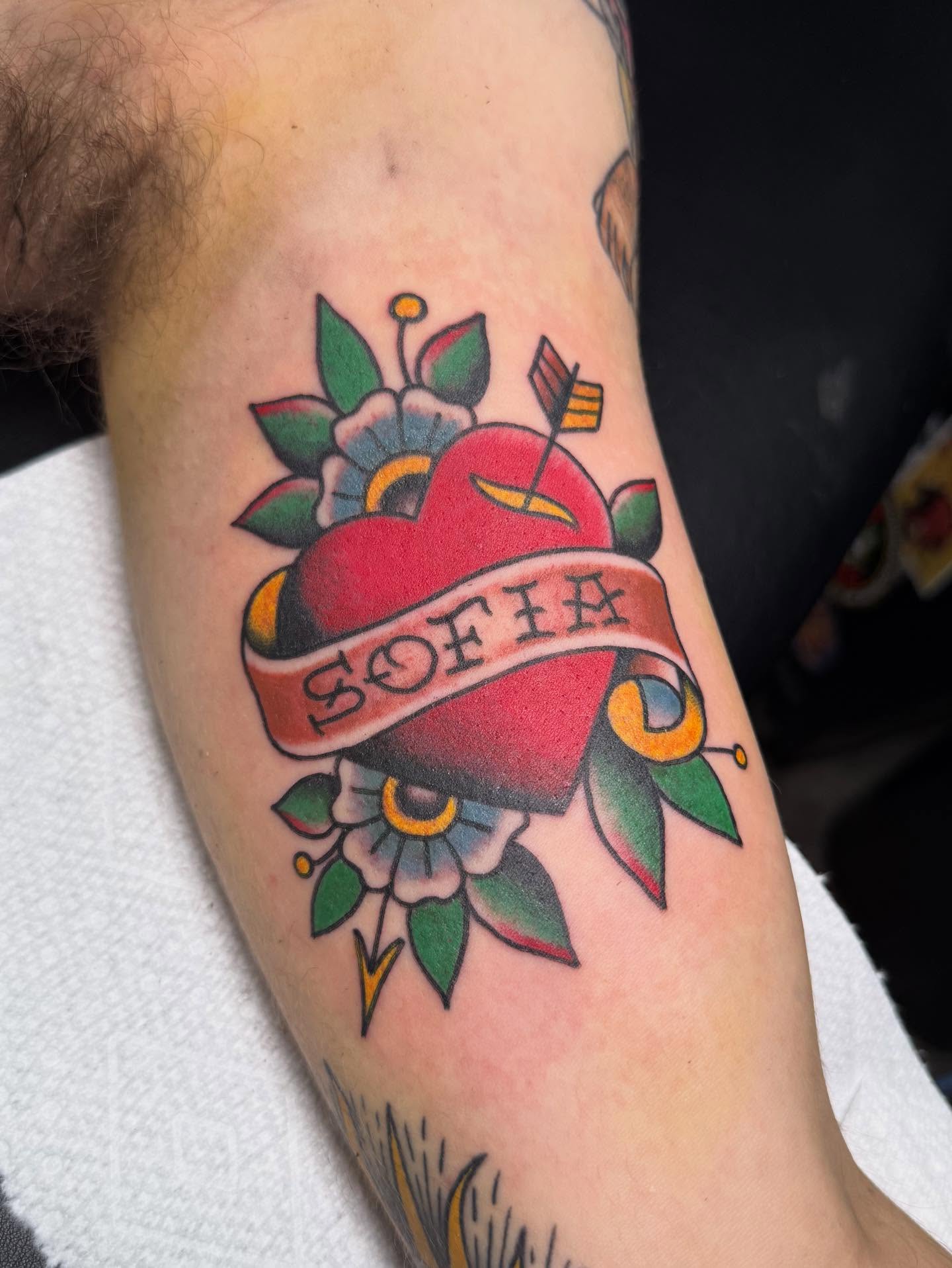 Heart with name banner American traditional tattoo on the forearm by Hannah Edwards, Austin, Texas