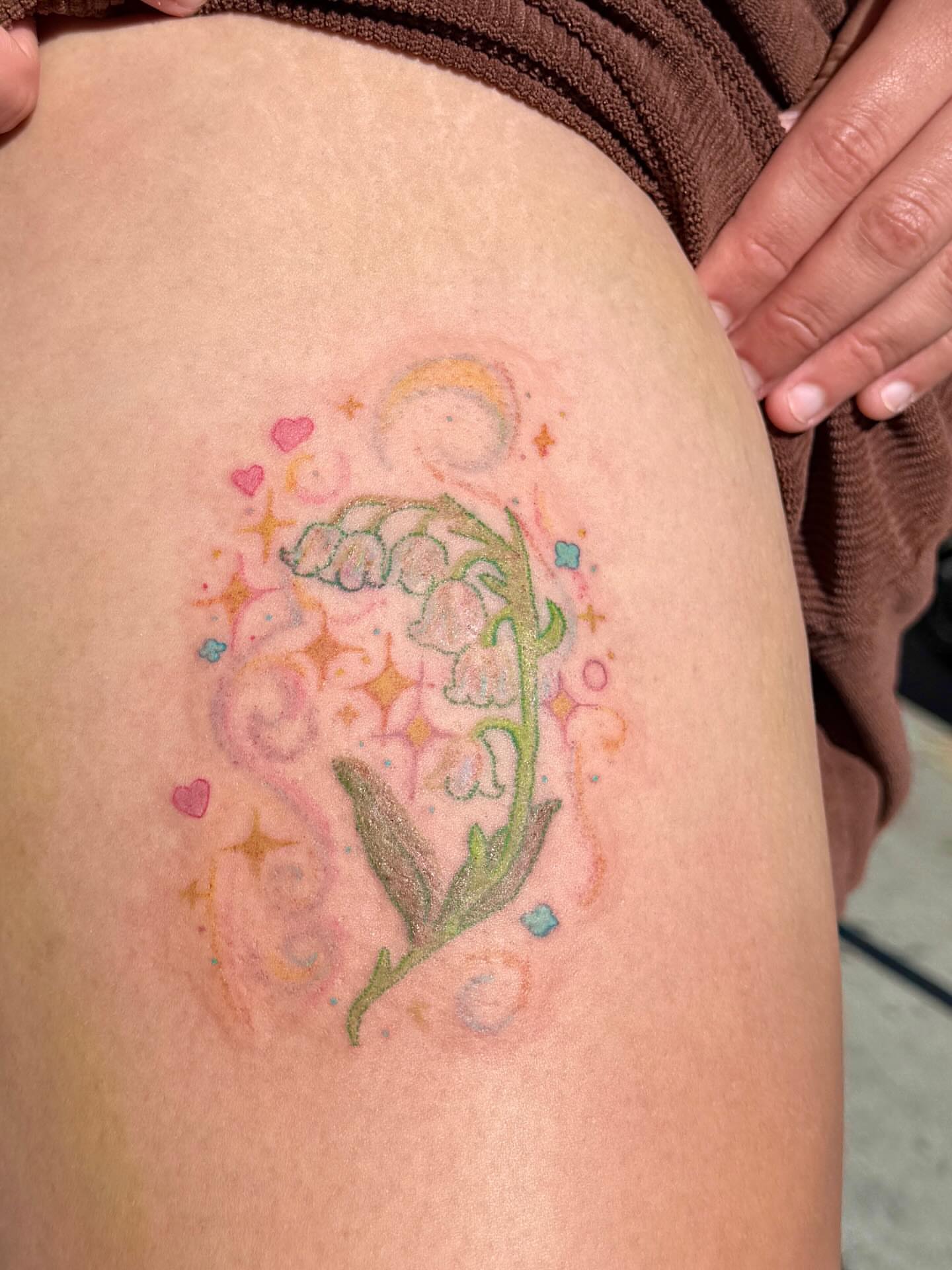 Lily of the valley watercolor tattoo on the thigh by Yez tattoo