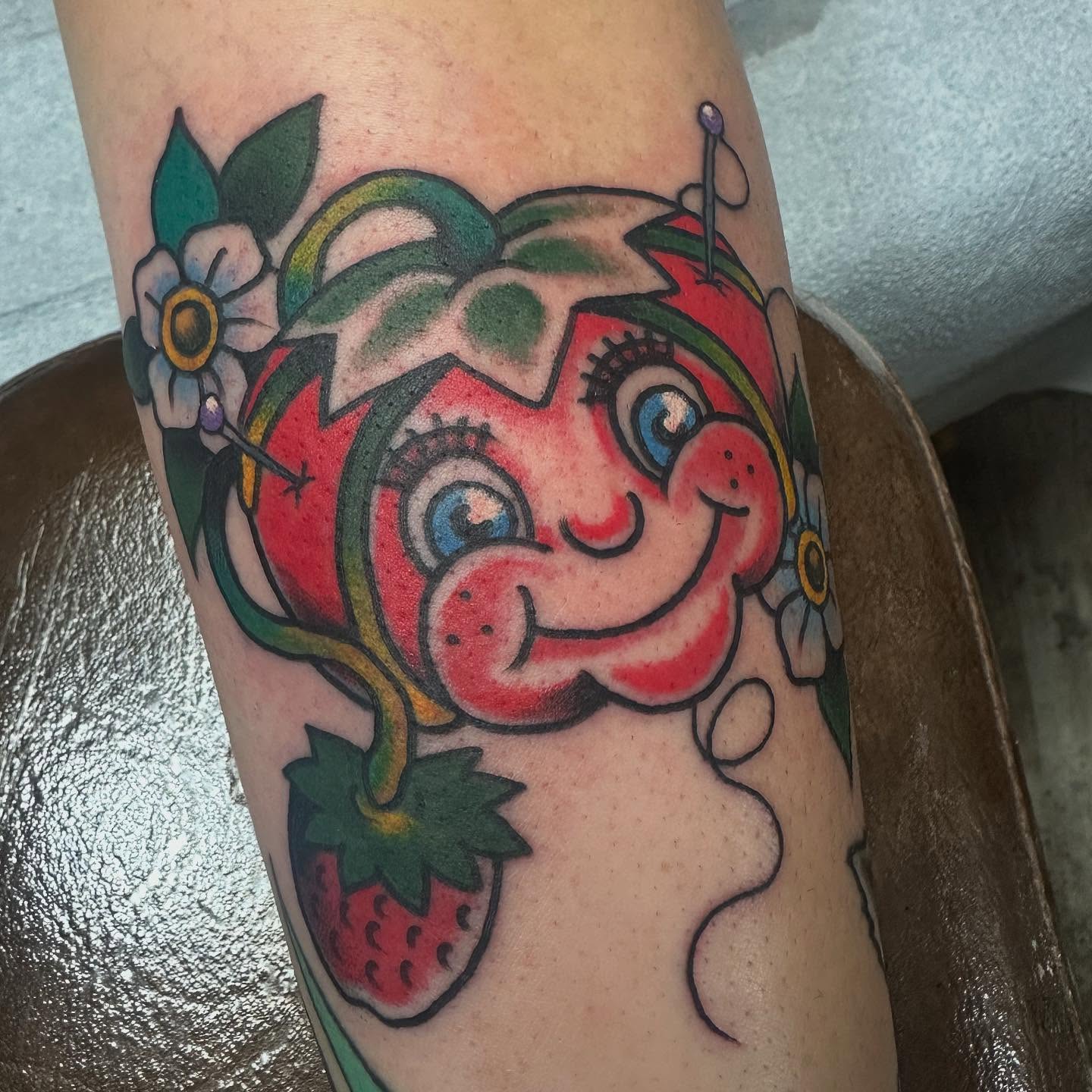 Strawberry character American traditional tattoo on the forearm by Devin Spenny
