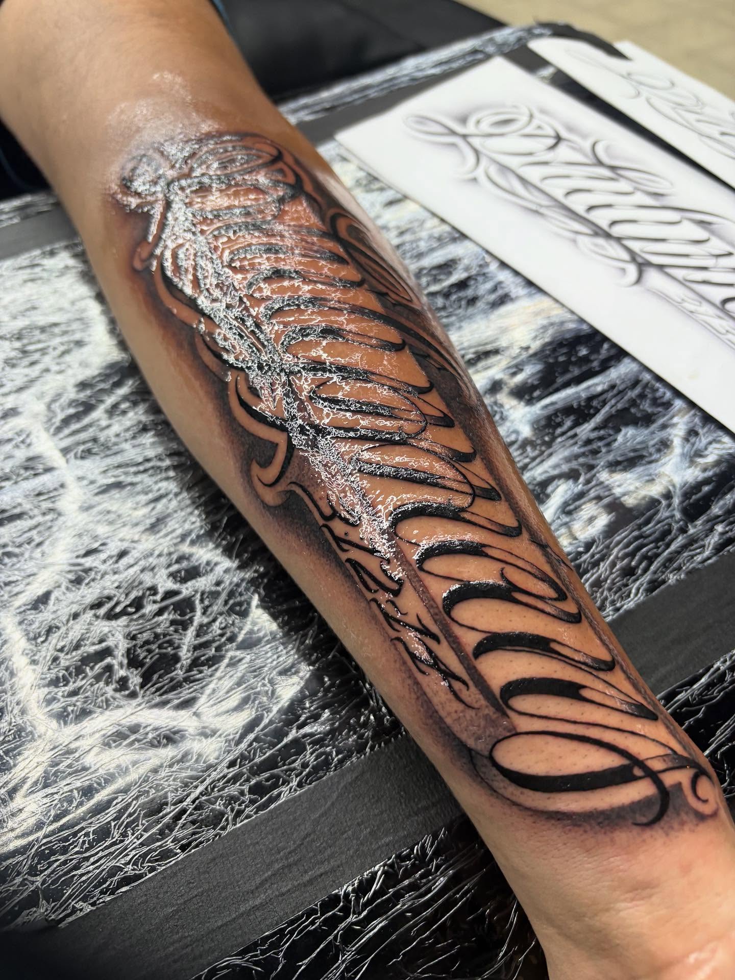 Feather black and grey tattoo on the forearm by Trusty Dizon Tattoo Artist