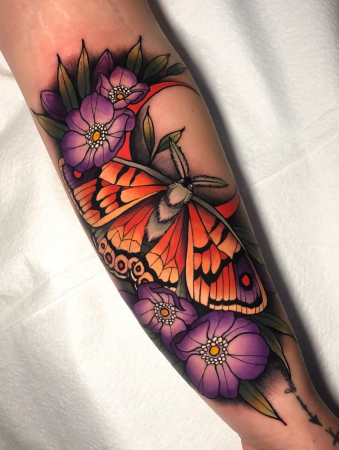 Butterfly and flowers realism tattoo on the forearm by Seth Holmes