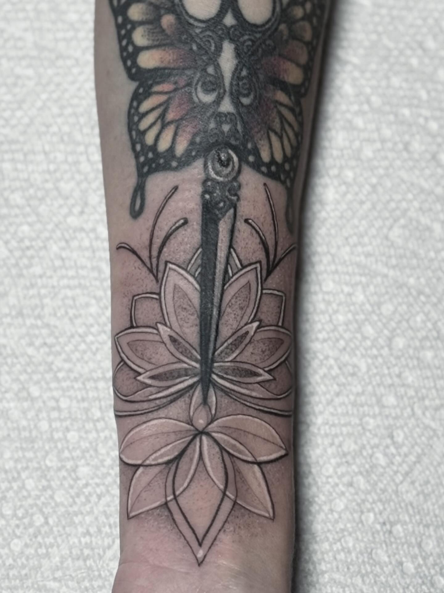Lotus flower and butterfly geometric tattoo on the forearm by Eric Axle