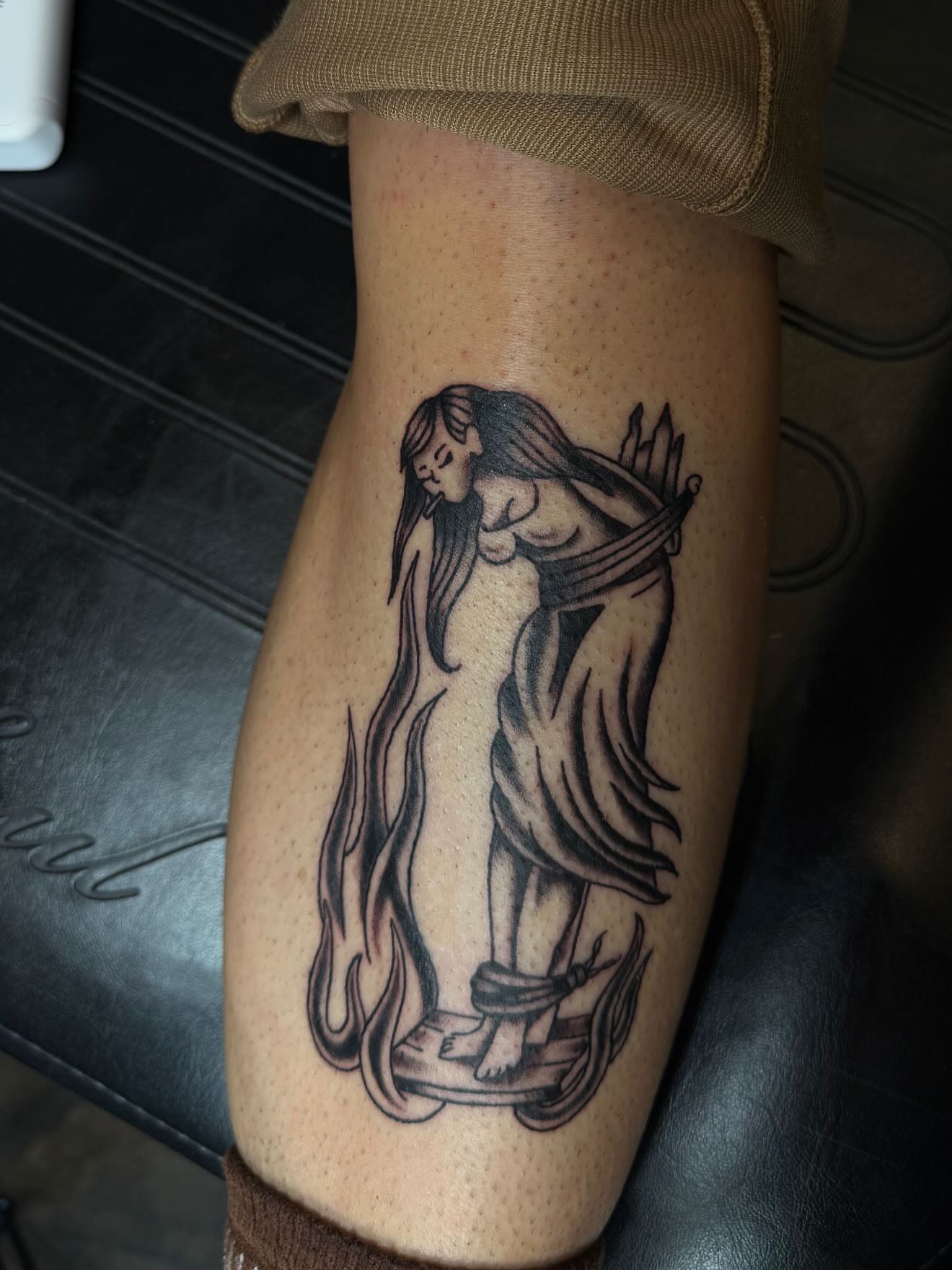 Woman with bow black and grey tattoo on the forearm by frankie quadrini
