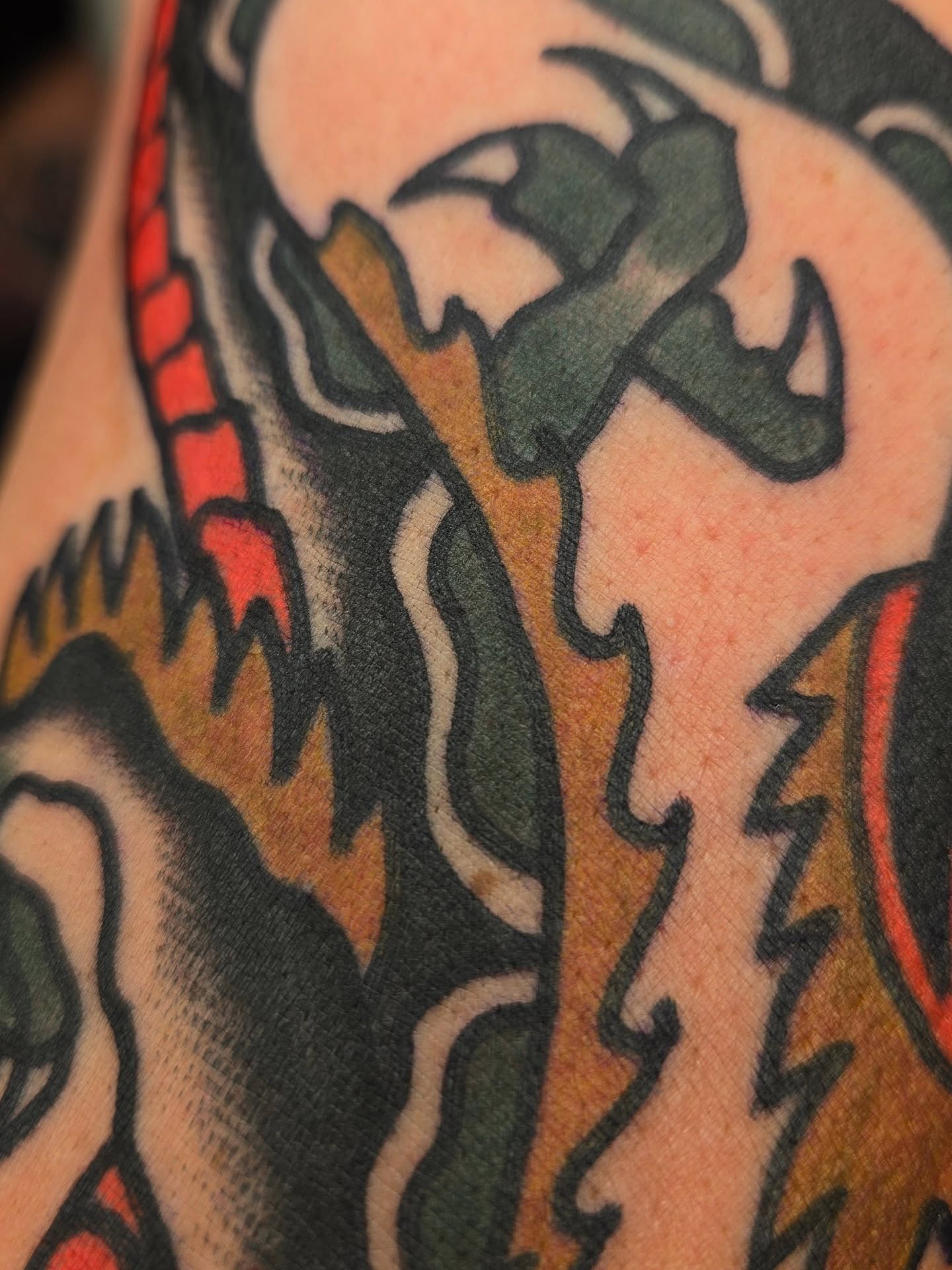 Dragon American traditional tattoo on the upper arm by Deke Harms, Bend, Oregon