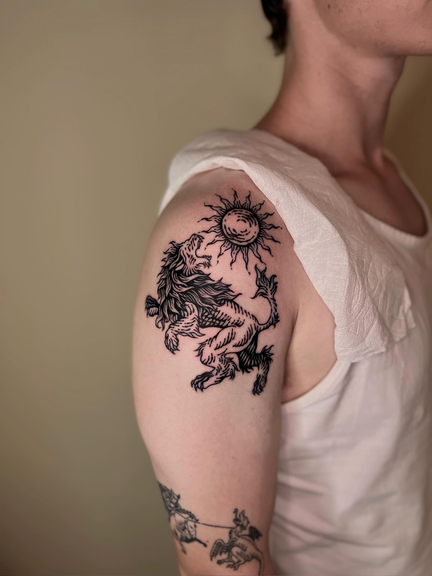 Lion and sun black and grey tattoo on the shoulder by Wonny