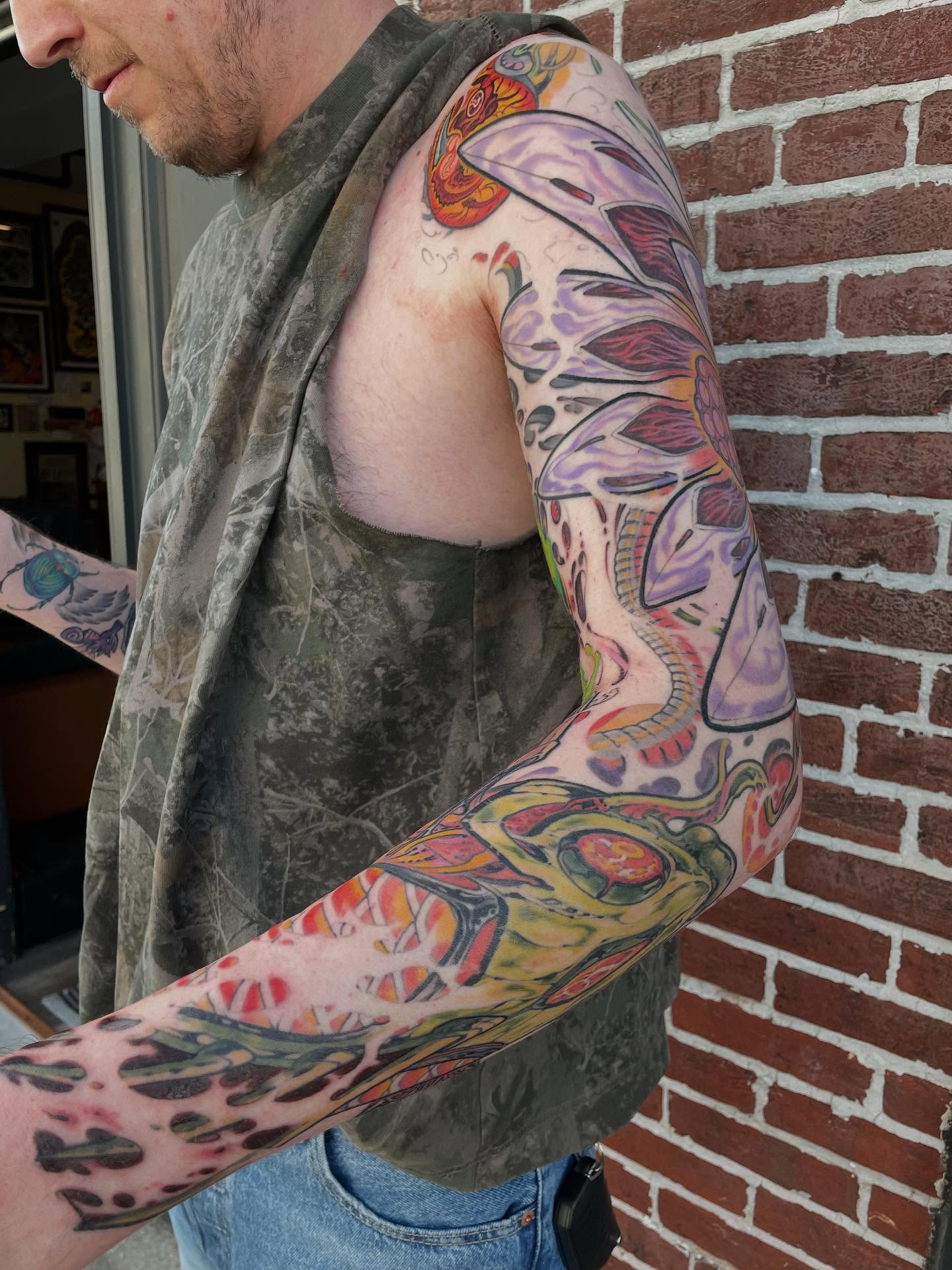 Abstract biomechanical new school tattoo on the upper arm by Billy Haines