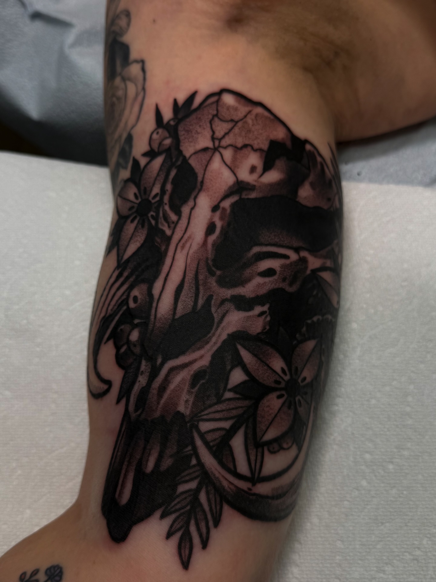Skull and flowers dotwork tattoo on the forearm by Jake lyon