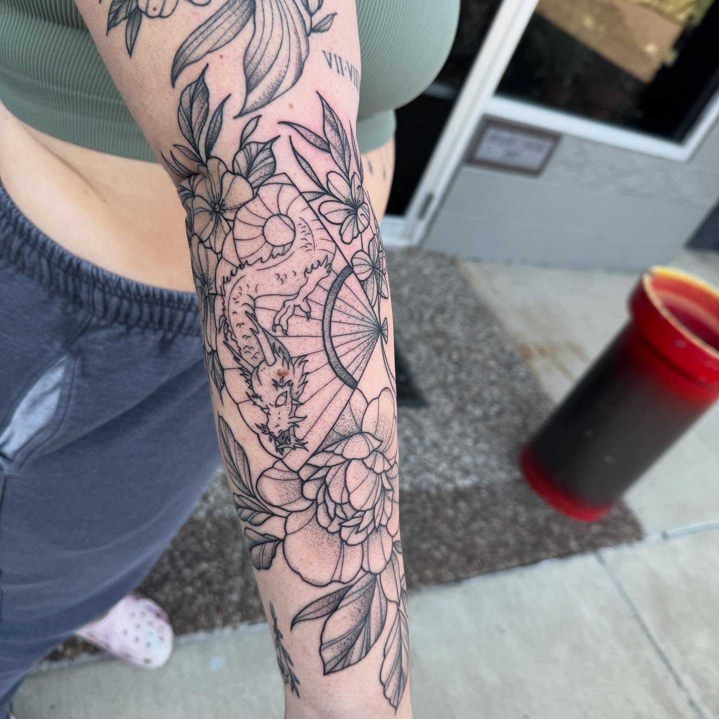 Dragon and floral dotwork tattoo on the forearm by Erica Rose π€