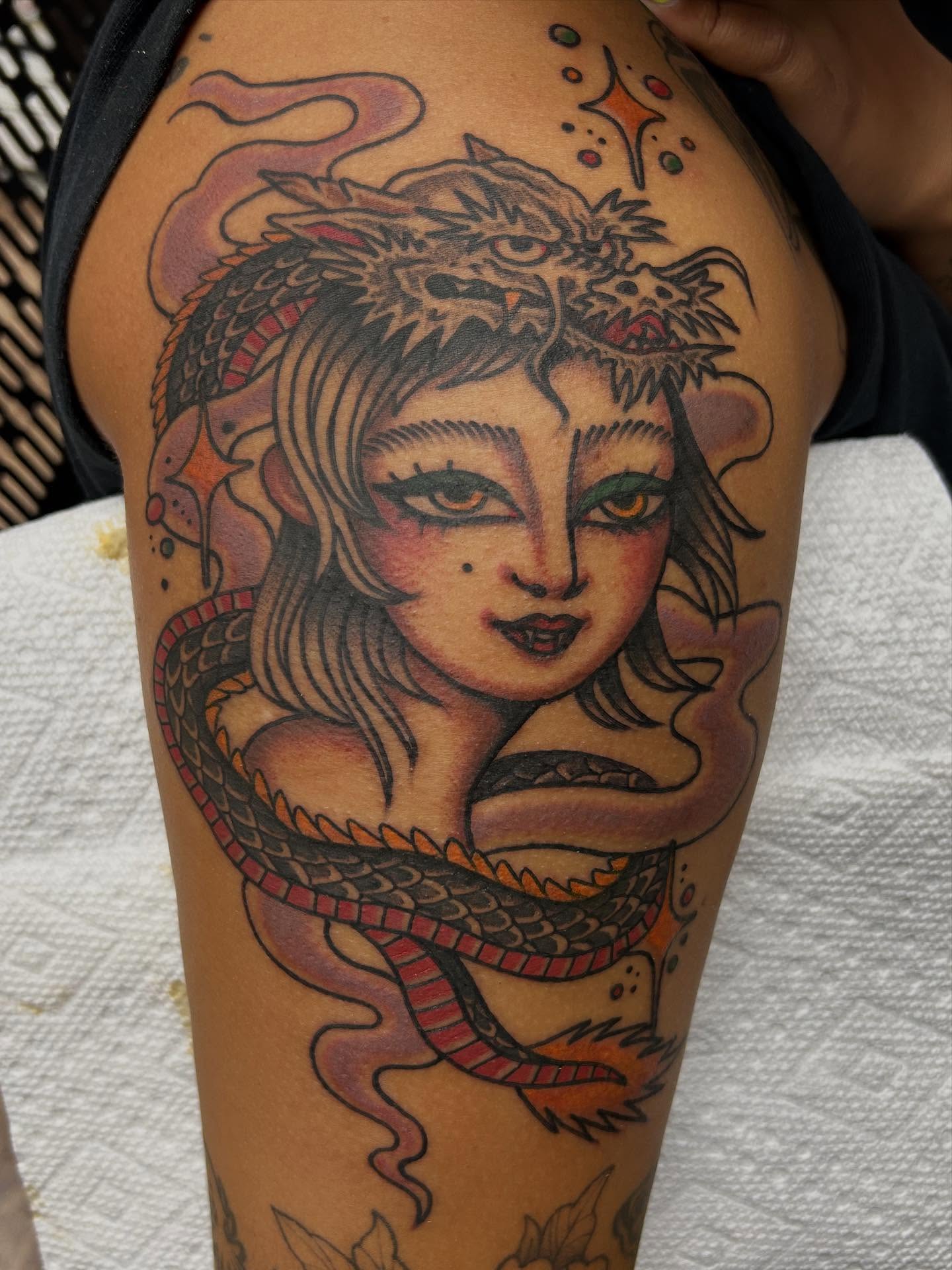 Woman with dragon American traditional tattoo on the upper arm by Tiffany Vargas
