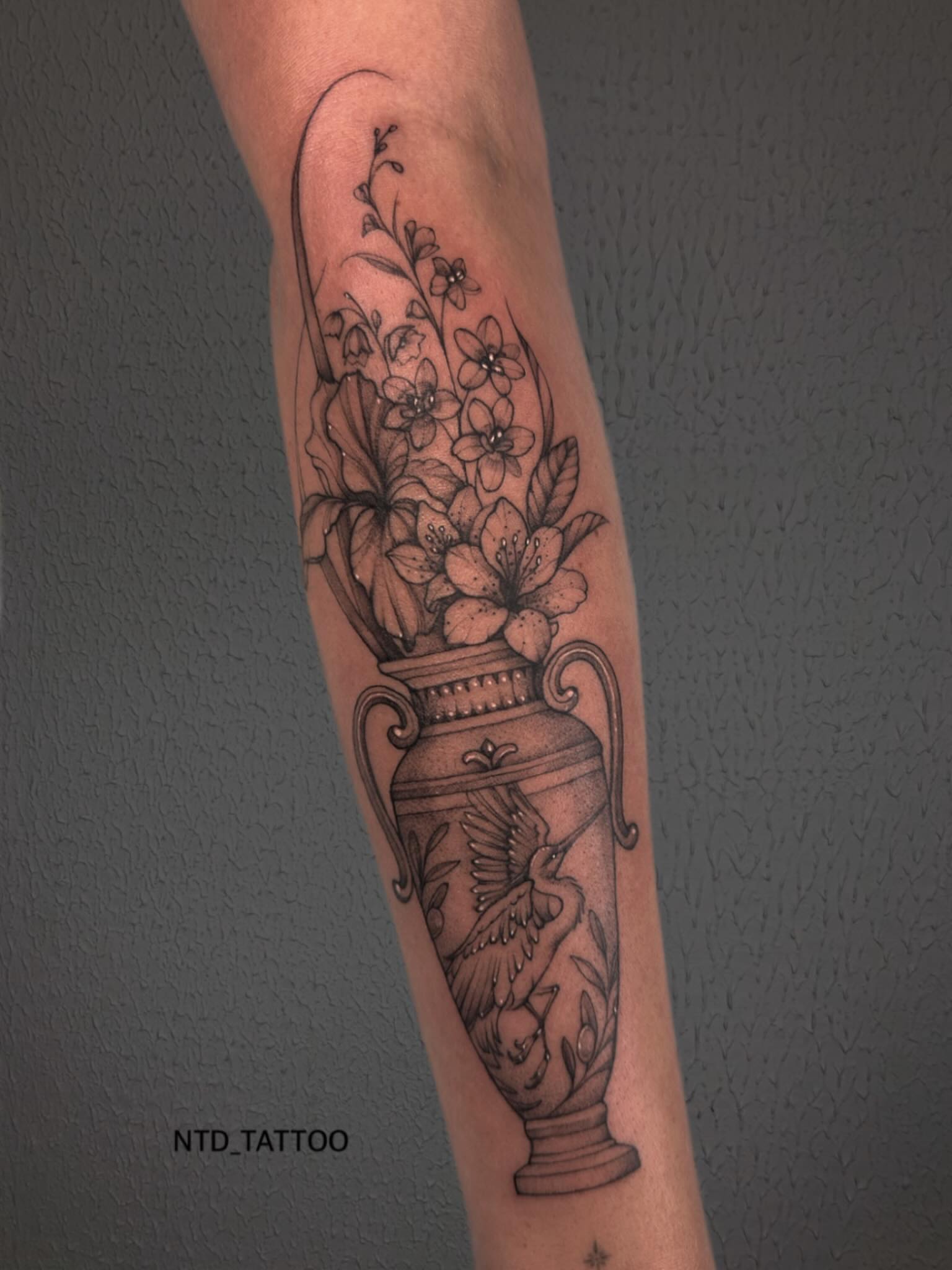 Urn with flowers black and grey tattoo on the forearm by Tetiana Maxon