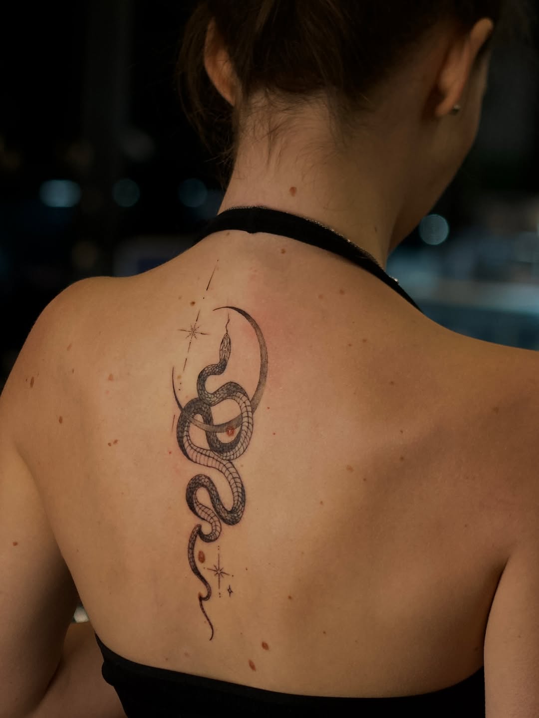 Snake and moon blackwork tattoo on the back by @blackastaratattoo