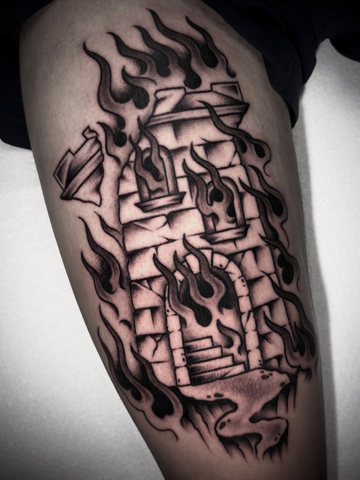 Fire and building black and grey tattoo on the thigh by Matt Elliott, Murfreesboro, Tennessee
