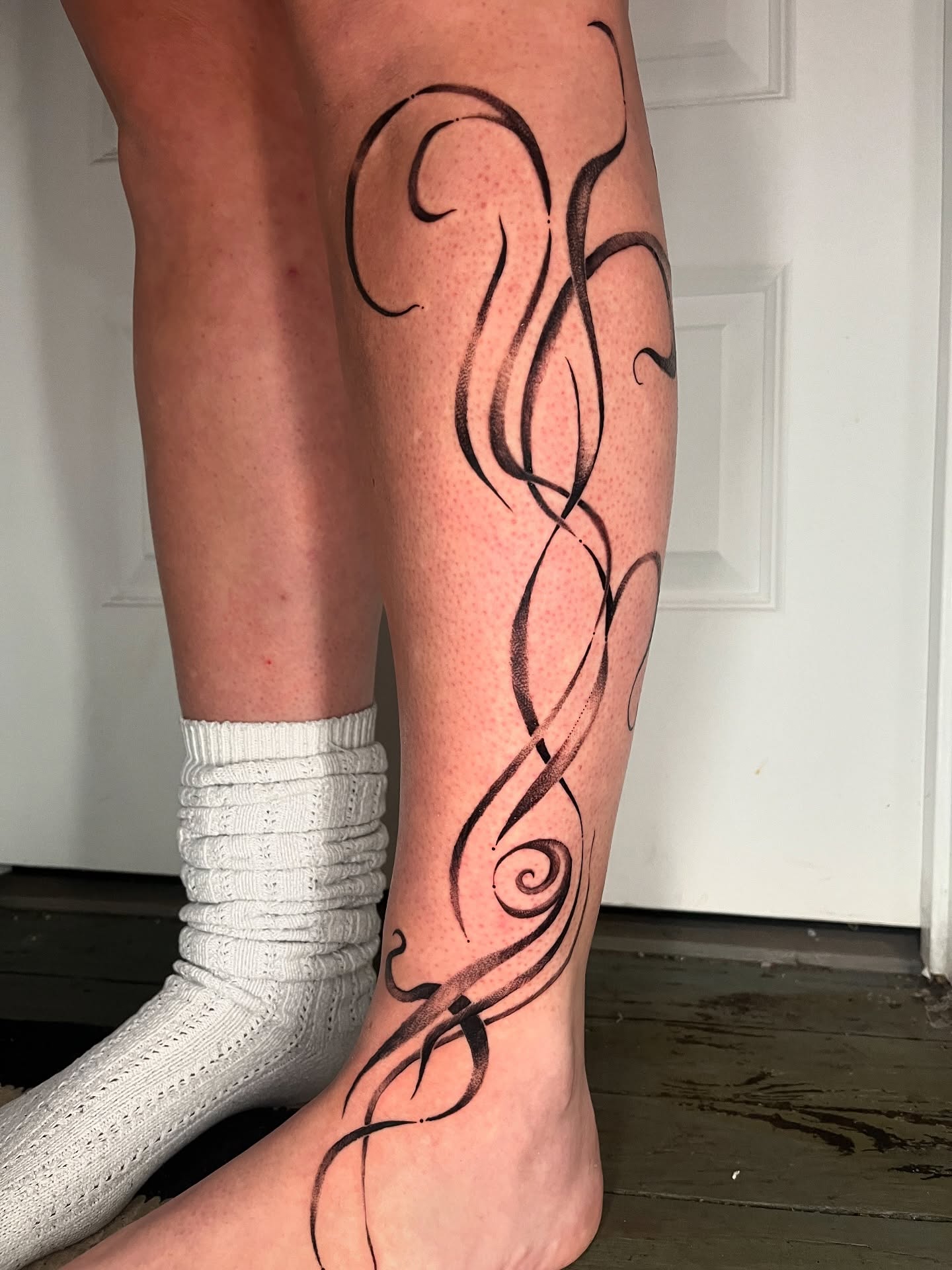 Swirls black and grey tattoo on the calf by layne