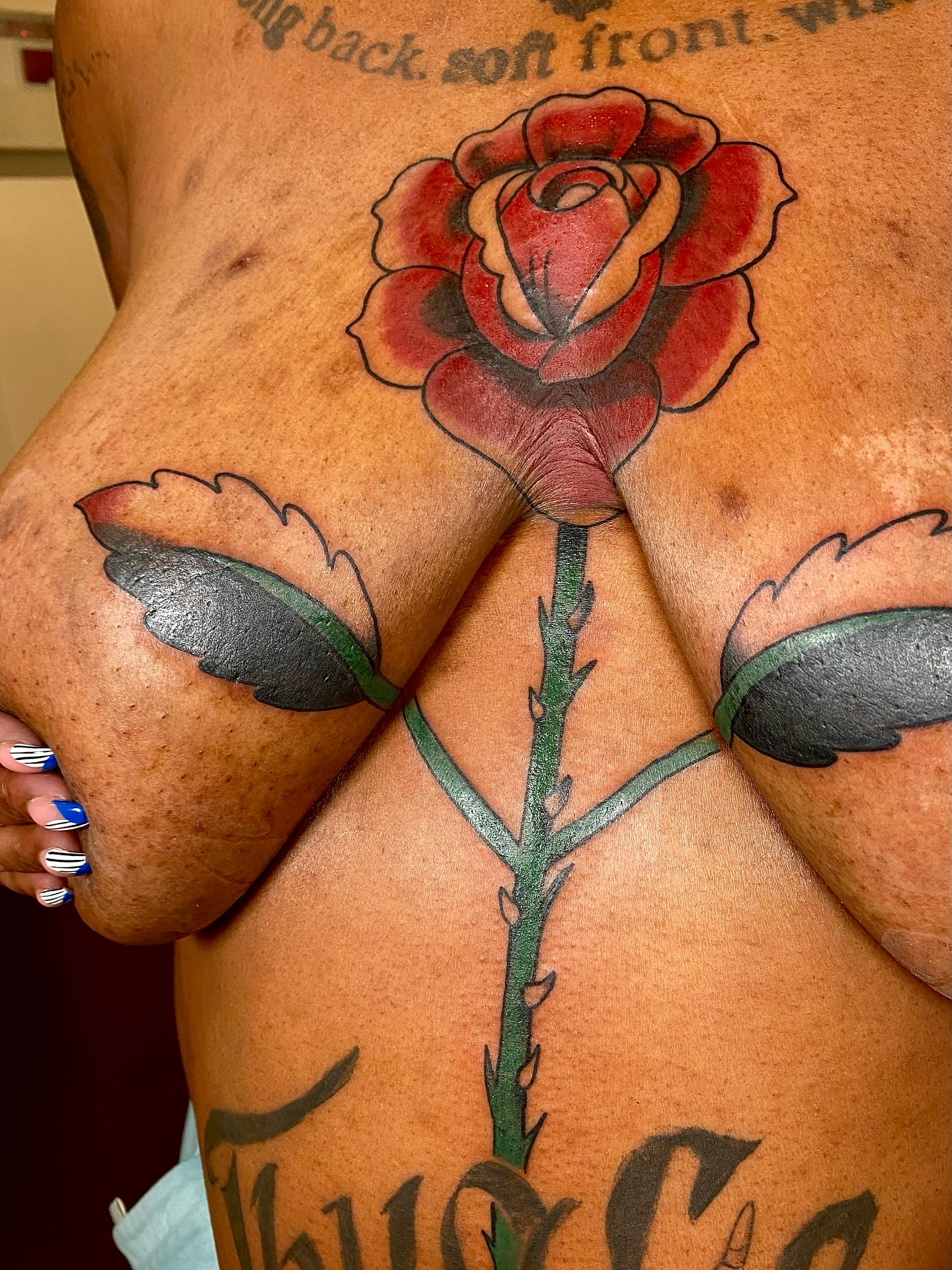 Red rose realism tattoo on the back by Sophie McTear