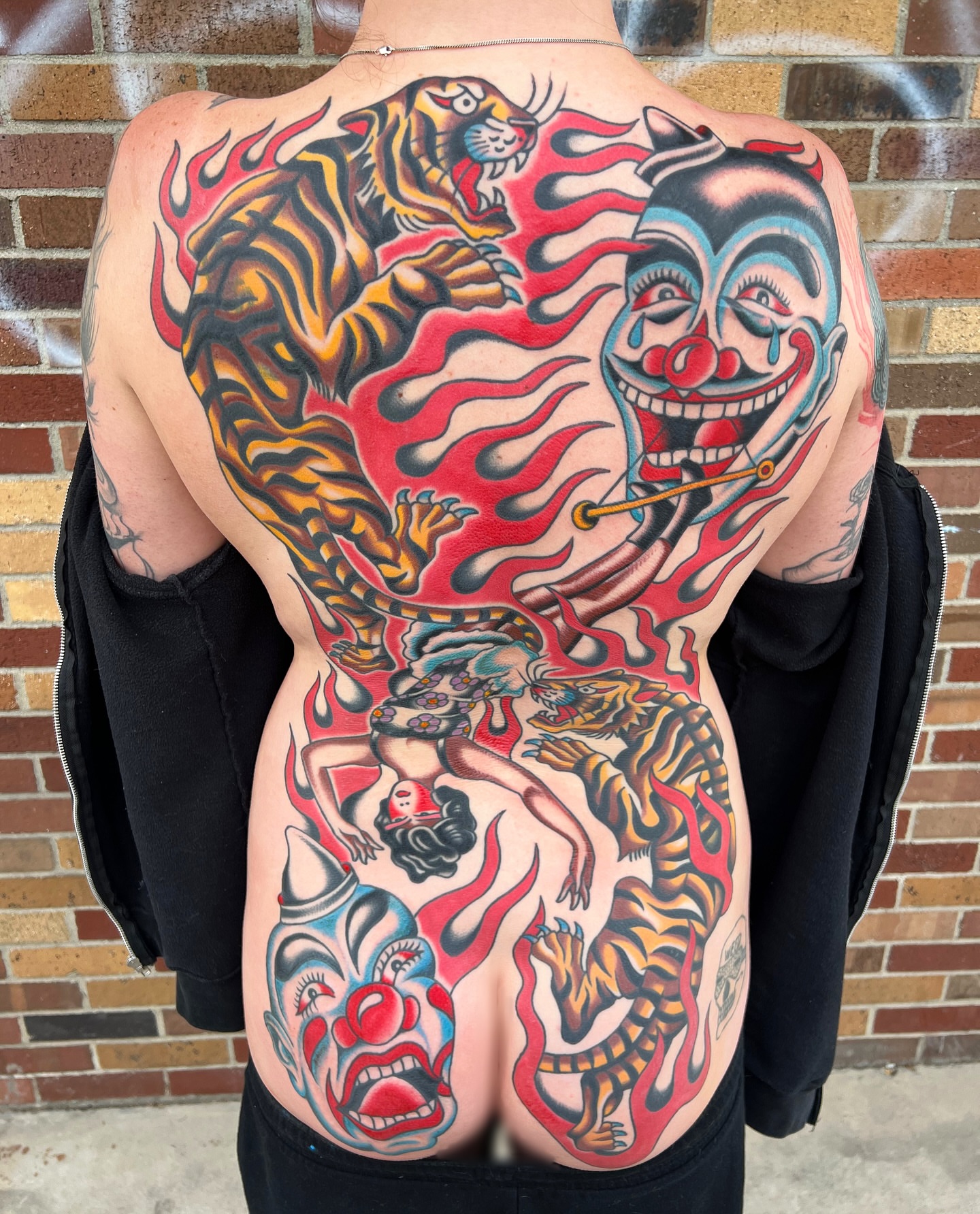 Tiger and clown American traditional tattoo on the back by Nick Judkins Tattoo