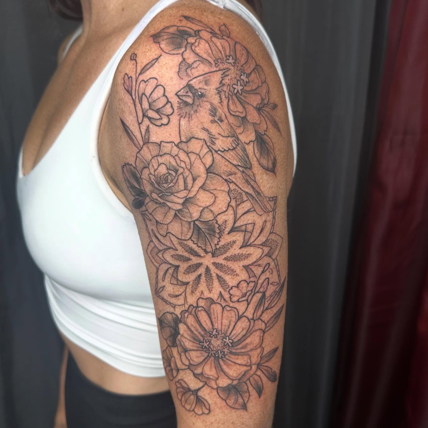 Floral bouquet dotwork tattoo on the upper arm by Halle Haas