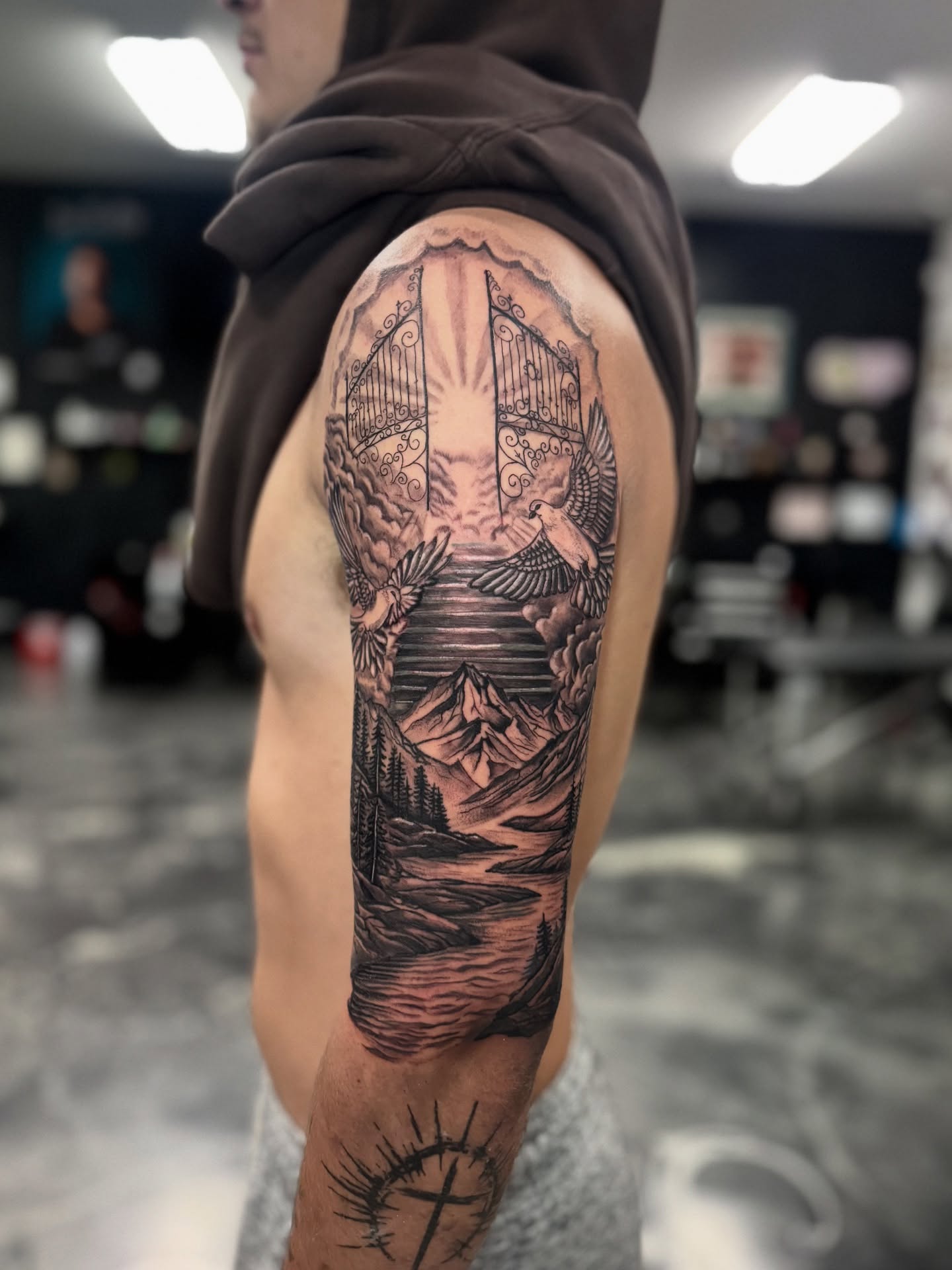 Heavenly gates and landscape realism tattoo on the forearm by Paola Pineda Tattoo, Knoxville, Tennessee