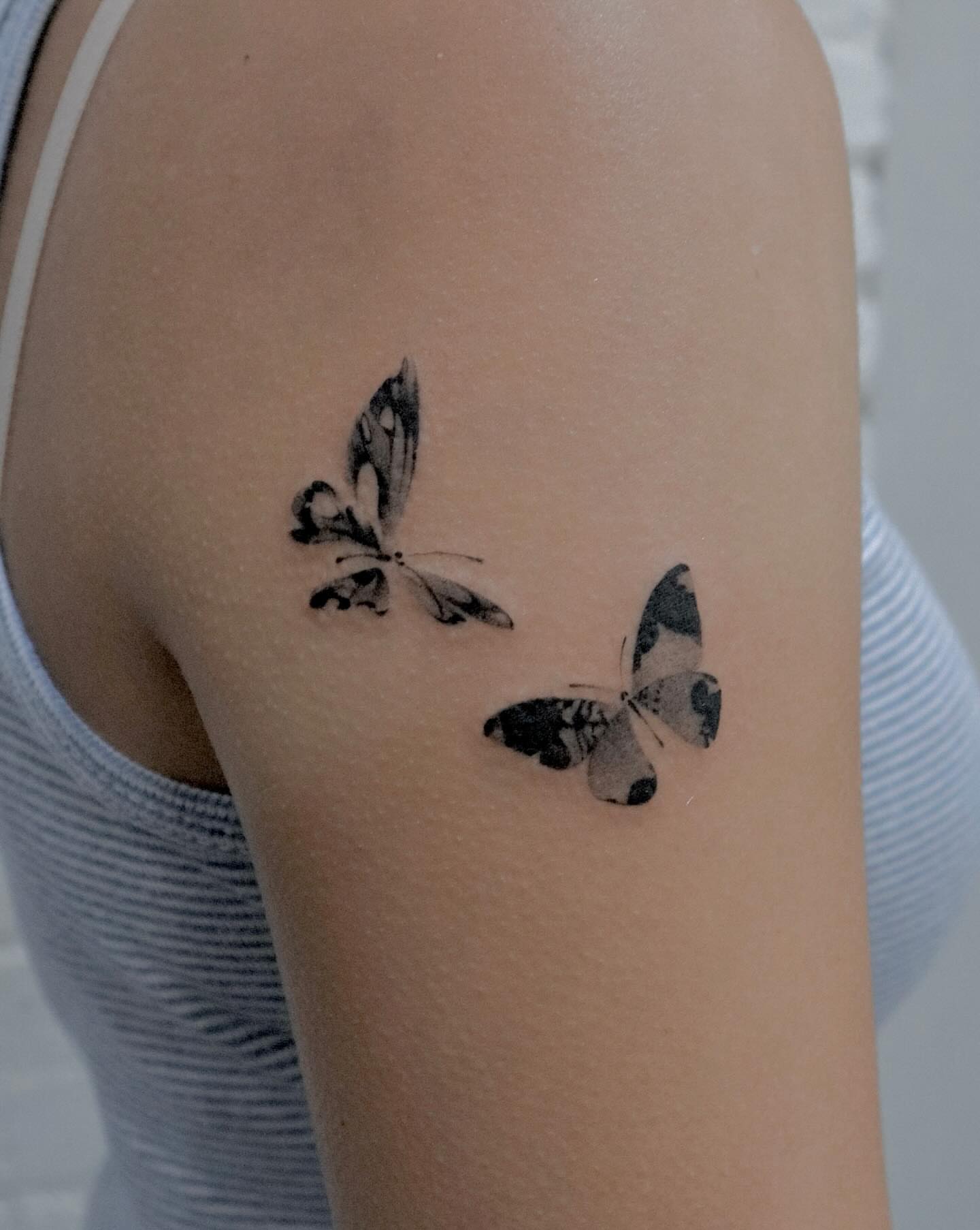Butterflies black and grey tattoo on the upper arm by River, New York, New York