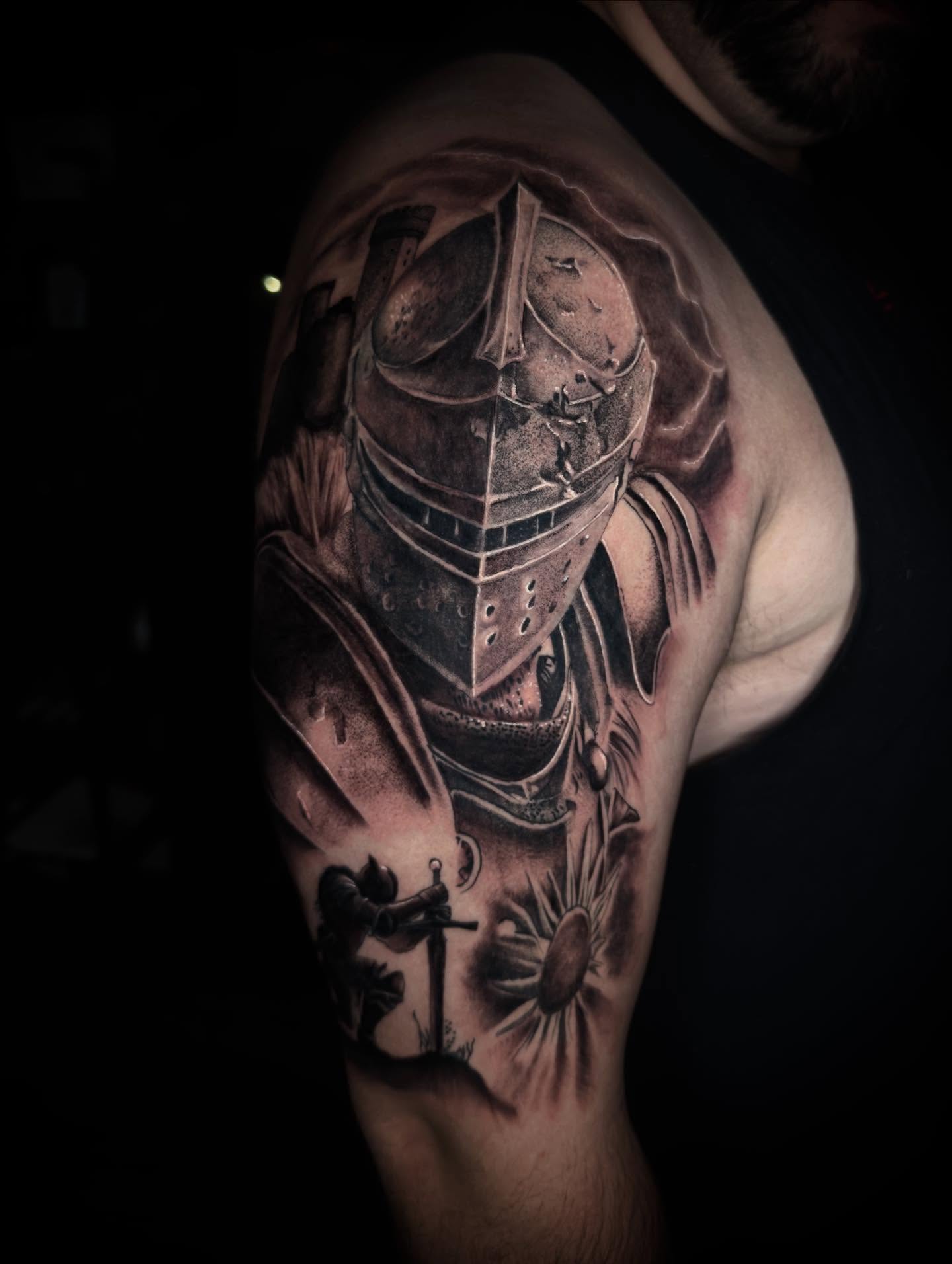 Knight helmet realism tattoo on the shoulder by Terence Taylor