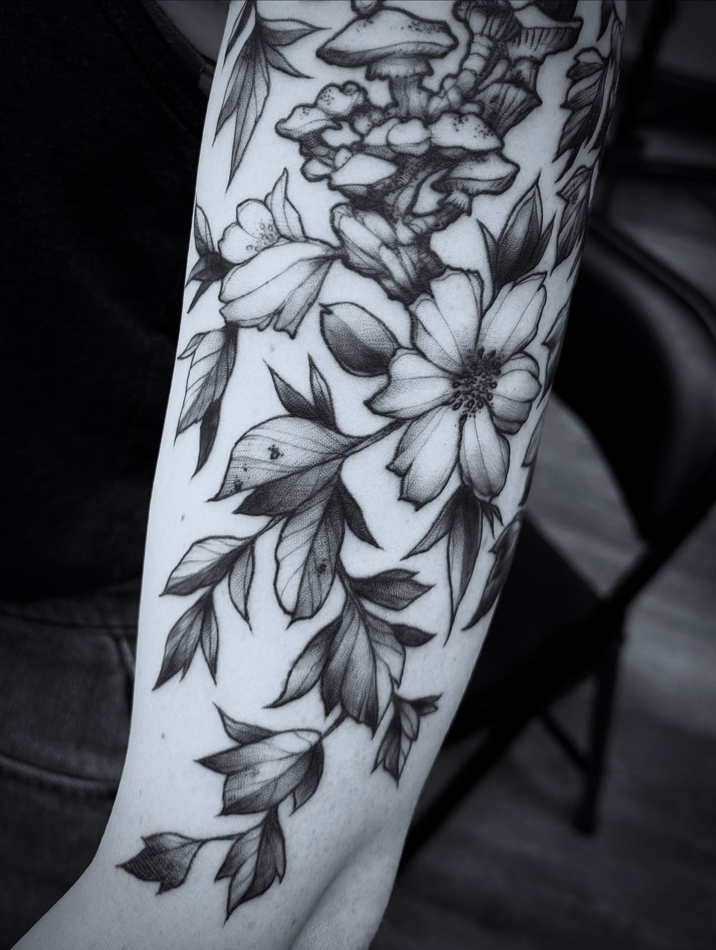 Flowers and mushrooms realism tattoo on the forearm by Michael Langdale