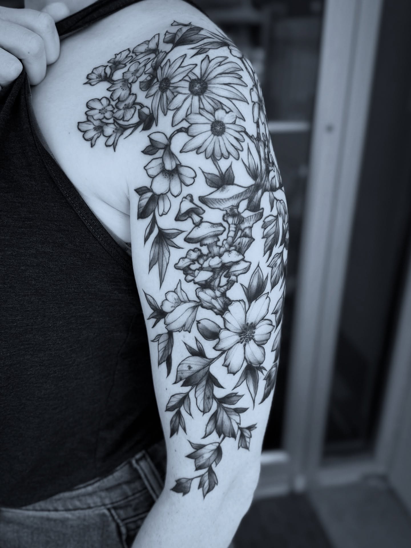 Floral bouquet black and grey tattoo on the upper arm by Michael Langdale