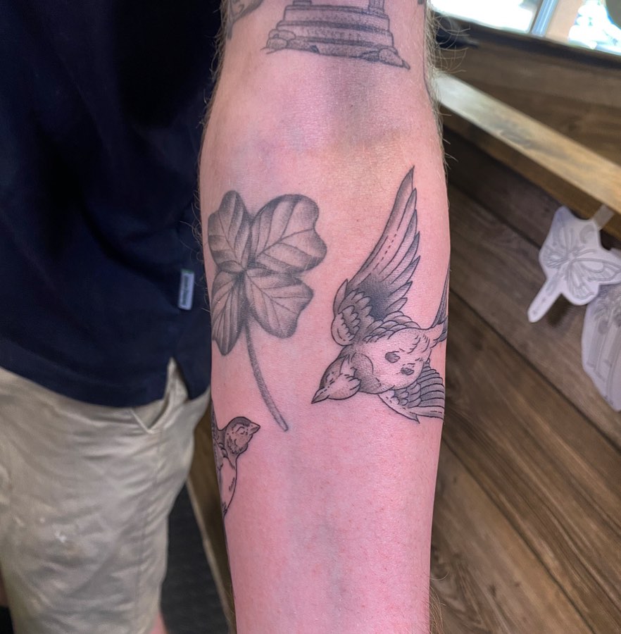 Bird and leaf black and grey tattoo on the forearm by Spencer Jones Tattoos