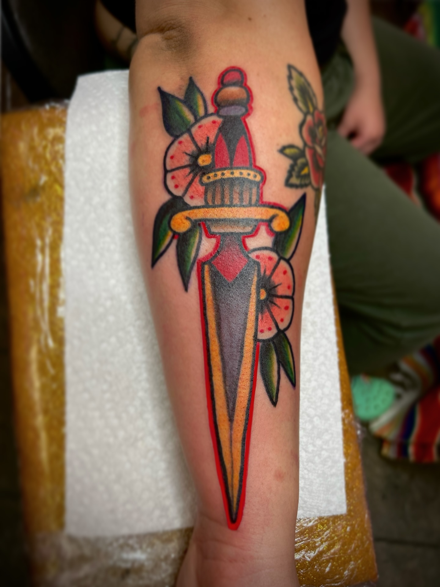 Dagger with flowers American traditional tattoo on the forearm by Ryan Willard, Denver, Colorado