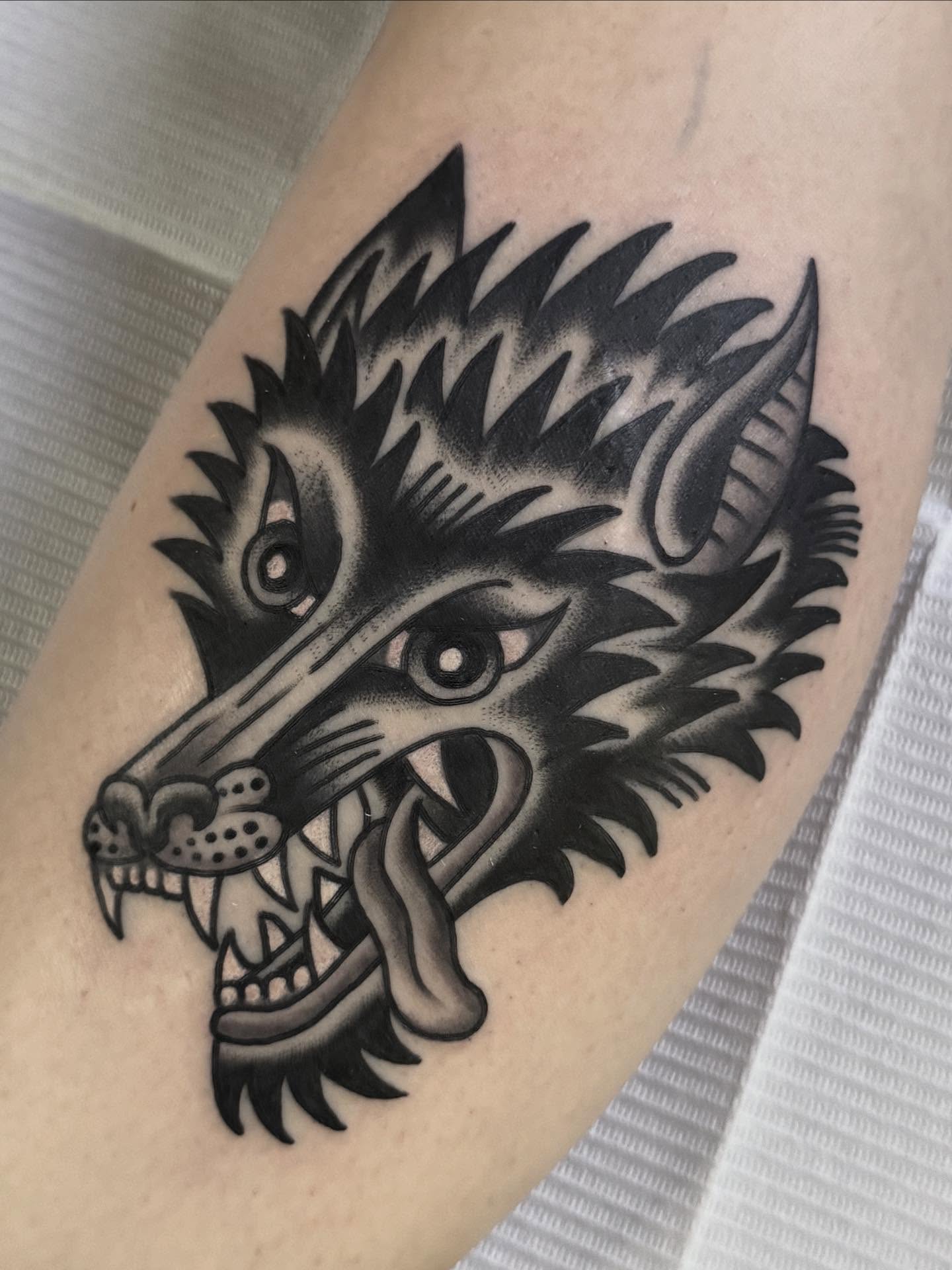 Wolf head black and grey tattoo on the forearm by Cory Craft