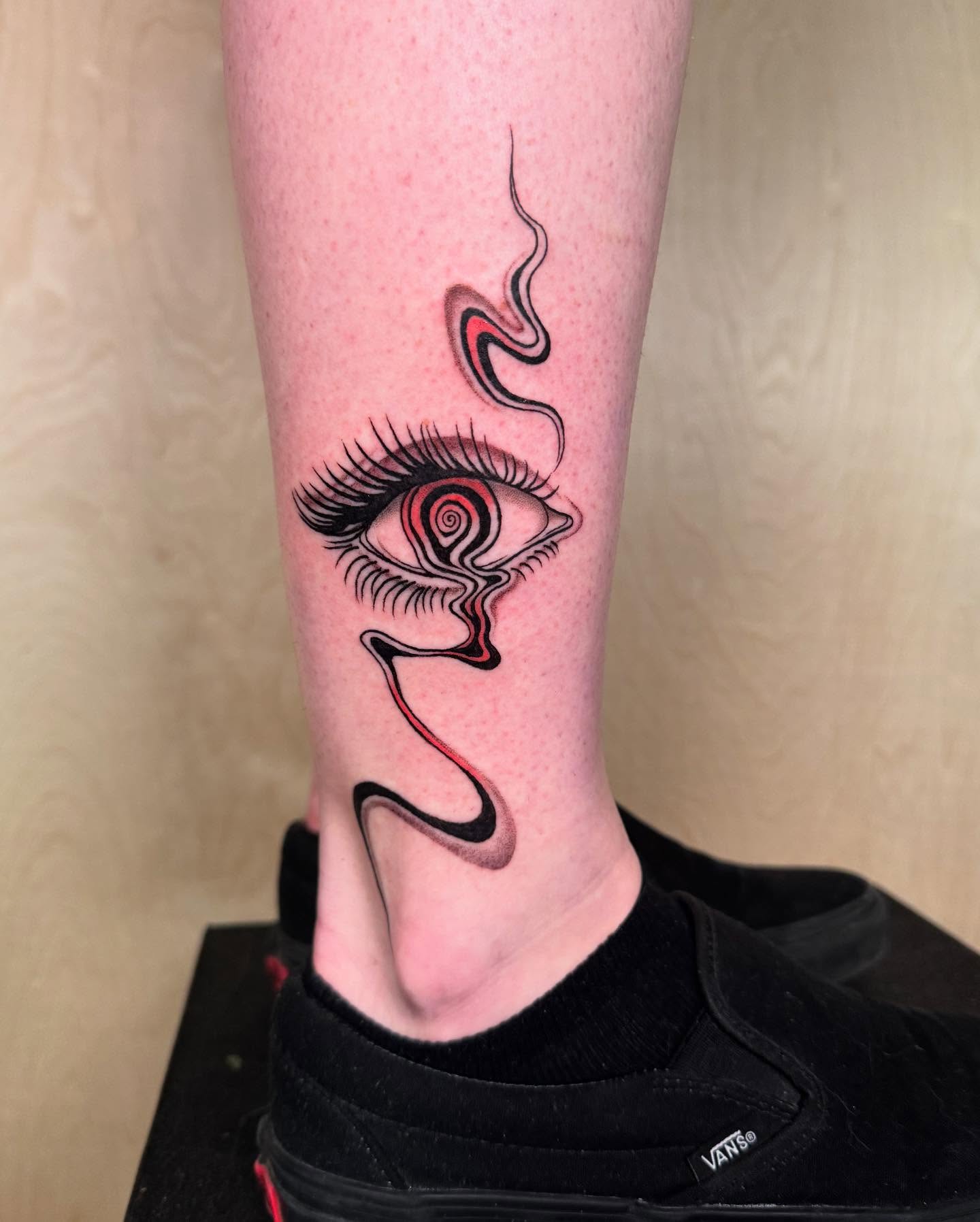 Eye with swirling pattern surrealism tattoo on the calf by Erin Blaney