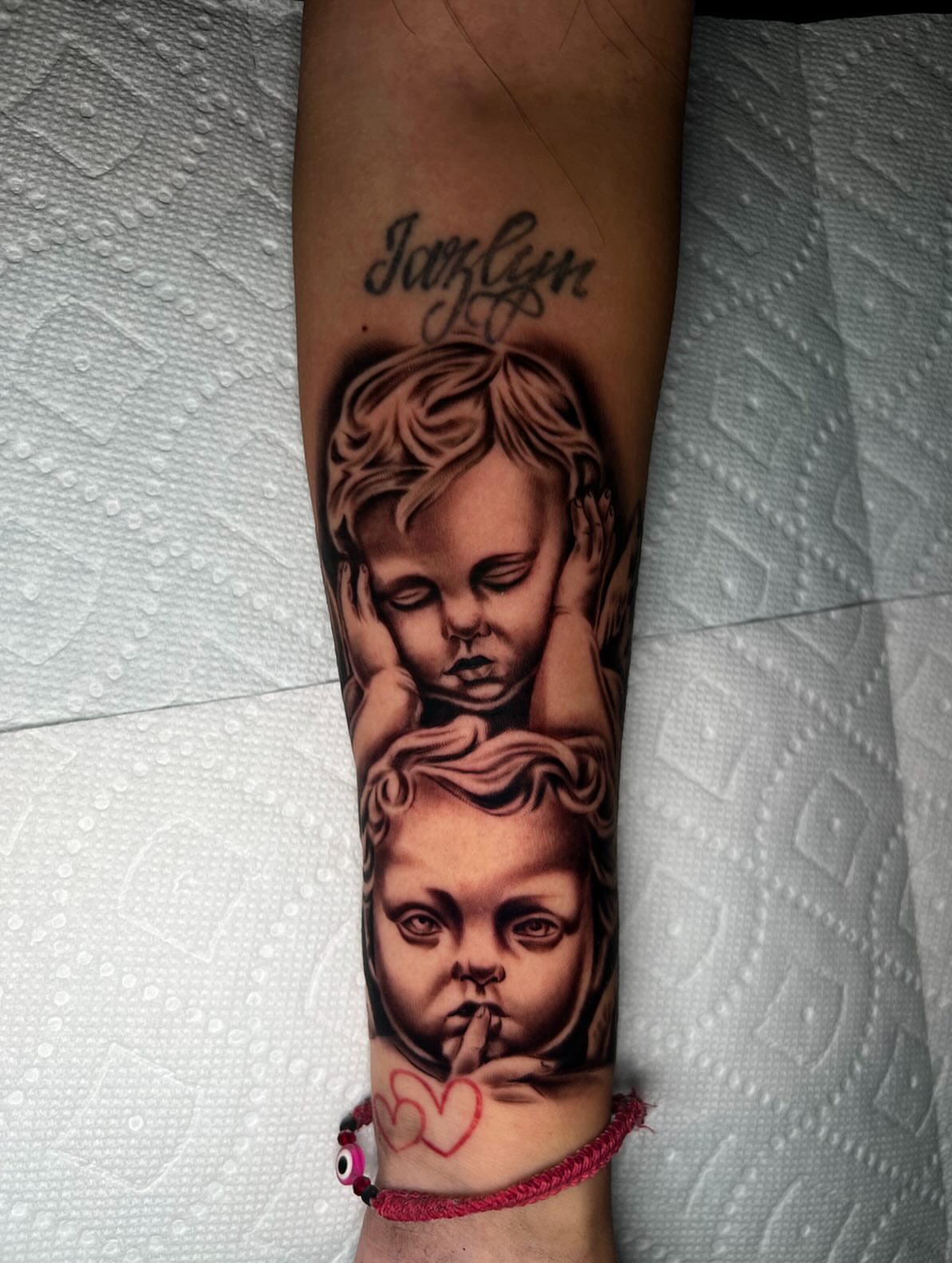 Child's head realism tattoo on the forearm by Kevyn Vidal